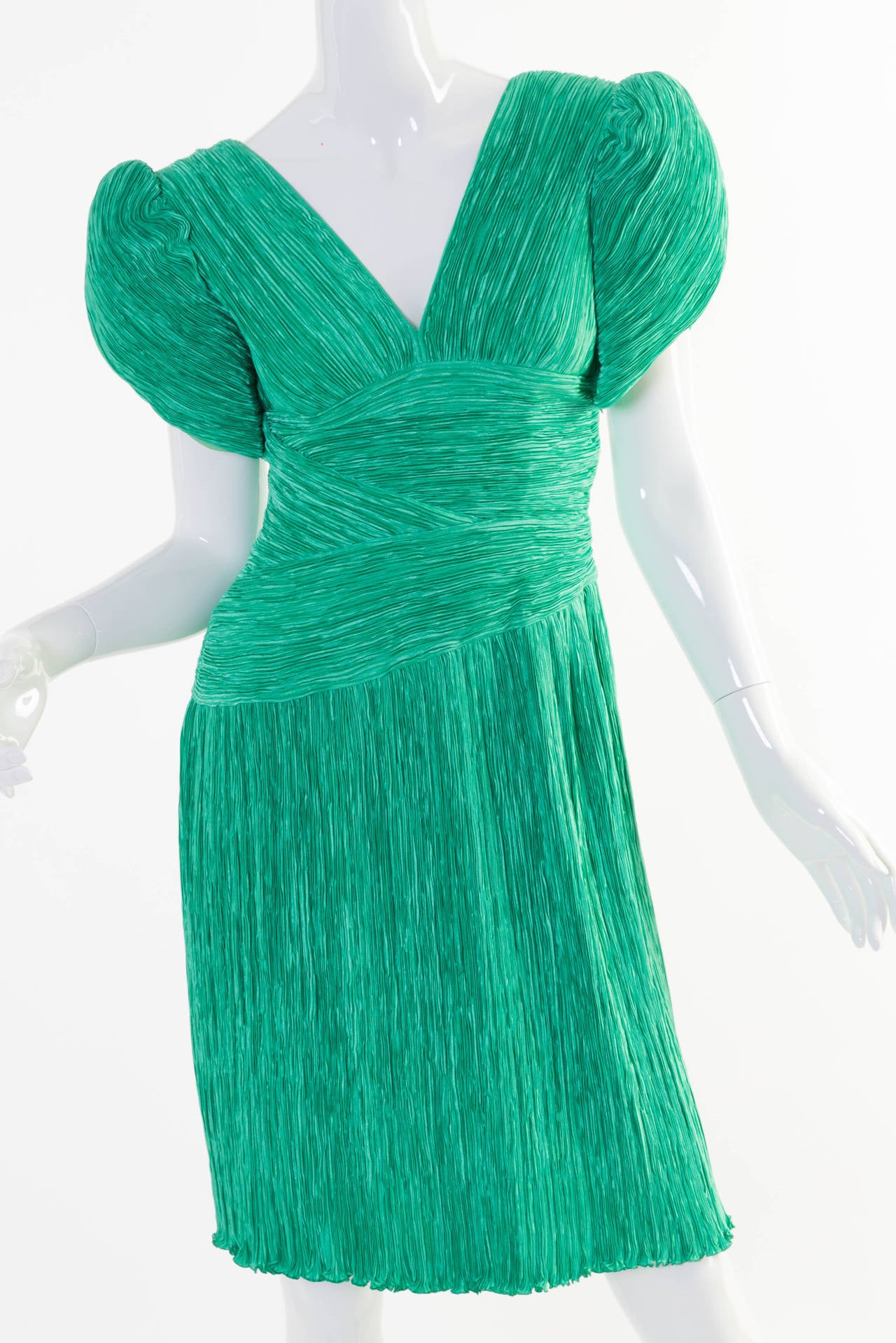 Mary McFadden couture green fortuny pleat dress.
The dress is lined throughout the bodice in a green silky feeling fabric, the sleeves are lined in organza and the skirt portion is unlined.
Closes on the side with a hidden zipper.
This dress is in