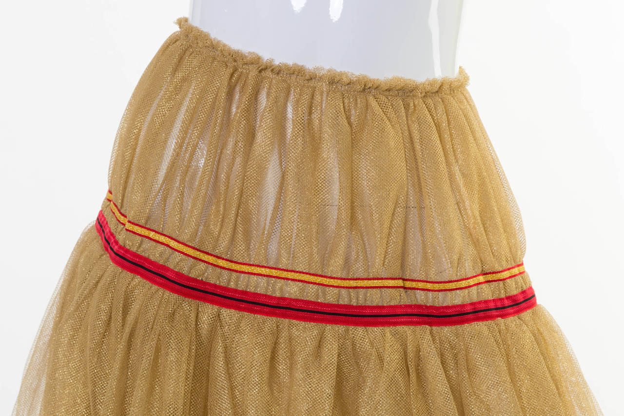Metallic gold tulle Comme des Garçons layered  avant - garde ballerina  skirt with yellow and red ribbon trim and clasp closure at waist. 
Measurements: Waist 28