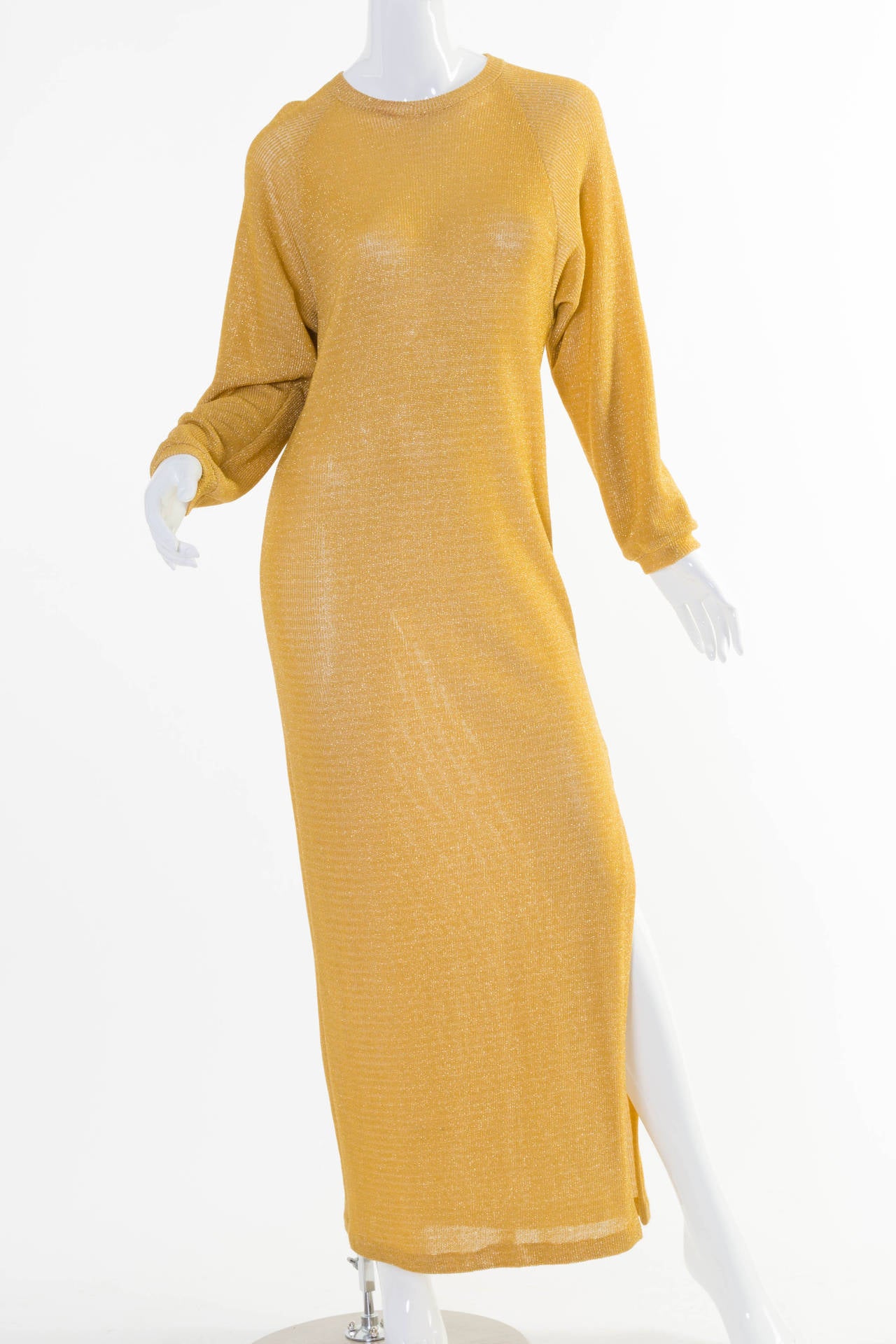 Bill Blass column maxi dress with a round neckline long sleeves and a slit on the left side of the gown. Made of a metallic gold knit with a generous amount of stretch to it. 

Bust: 36 inches 
Waist: 38 inches 
Hips: 38 inches 
Shoulders side