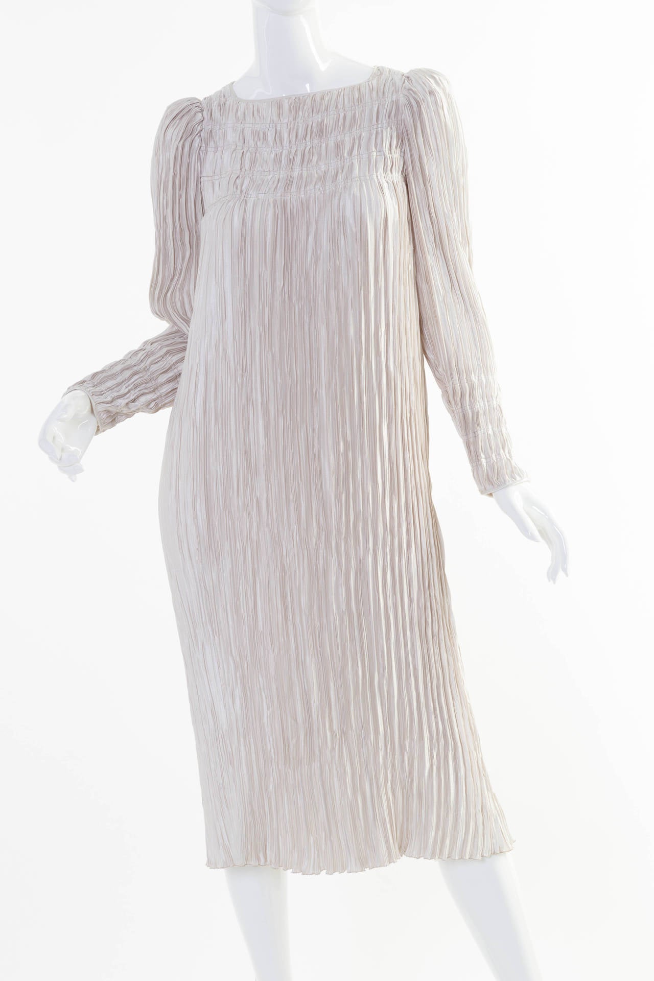 This  is   Mary McFadden Couture dress is made up of fortuny style pleats. The color is a silver grey, (with out being metallic).  The sleeves are long and can be worn scrunched up as well. The length is about mid calf. This dress also comes with an