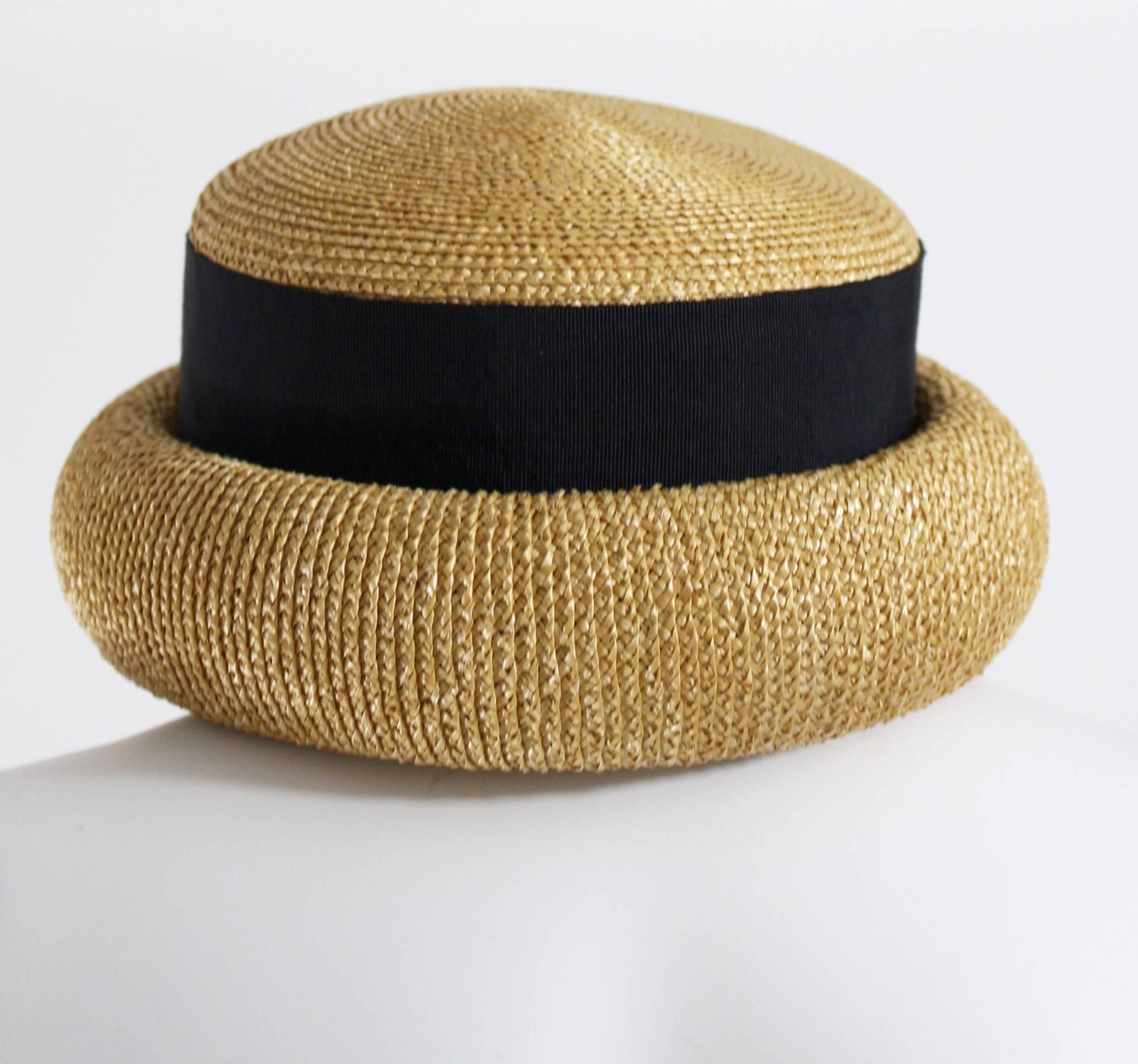 A chic Chanel woven straw hat with a black wide grosgrain ribbon band.
The brim is rolled. Marked a size 57
Measurements:
Inside Circumference: 21 inches
Height of Crown 4 inches
