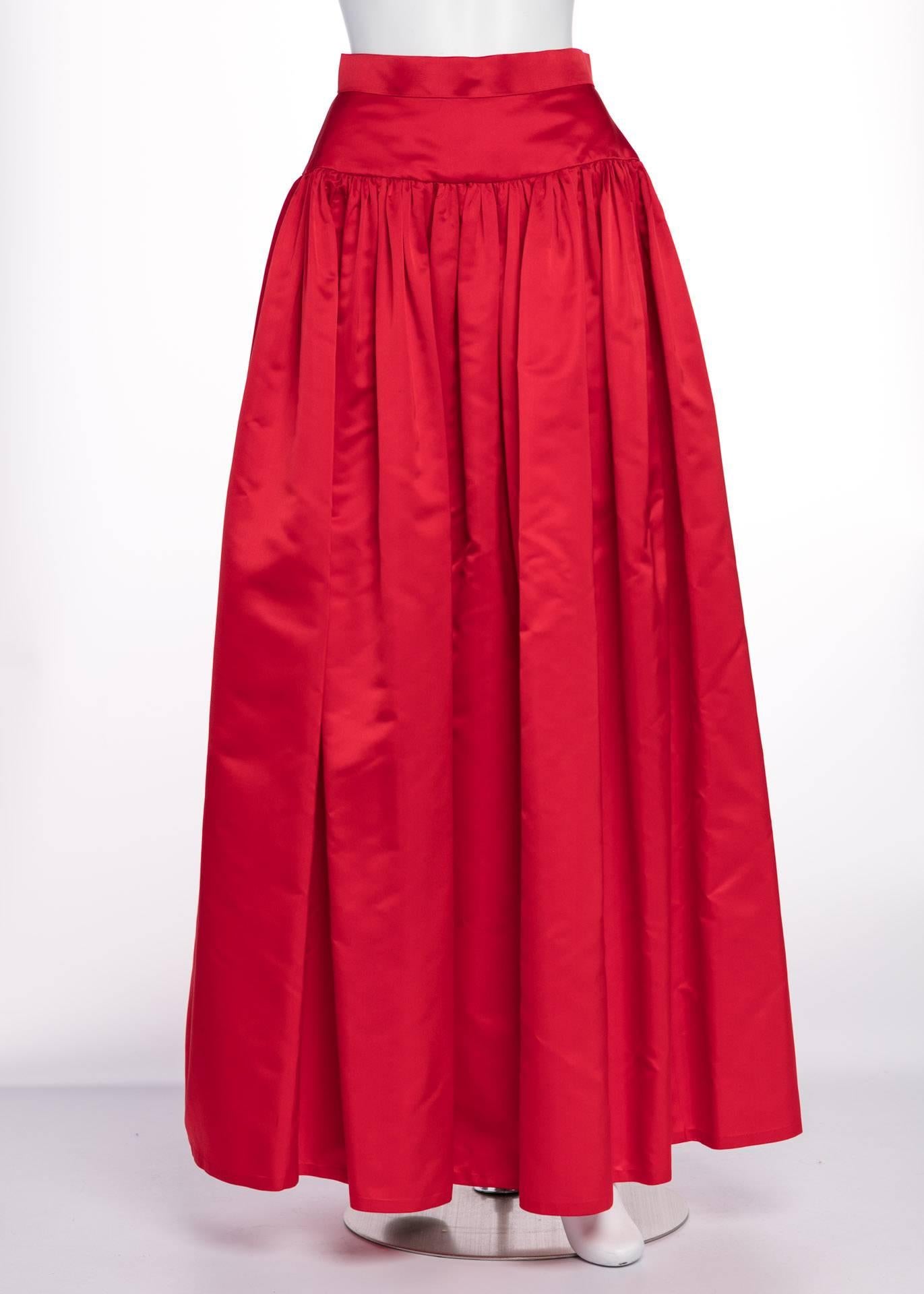 Bill Blass reveled in 1980s fashion, designing garments with big gestures and bold colors. The crimson red of this skirt spills smoothly over the hips with a beautifully lined yoke. Gathers of red satin fall to full length with the crisp satin