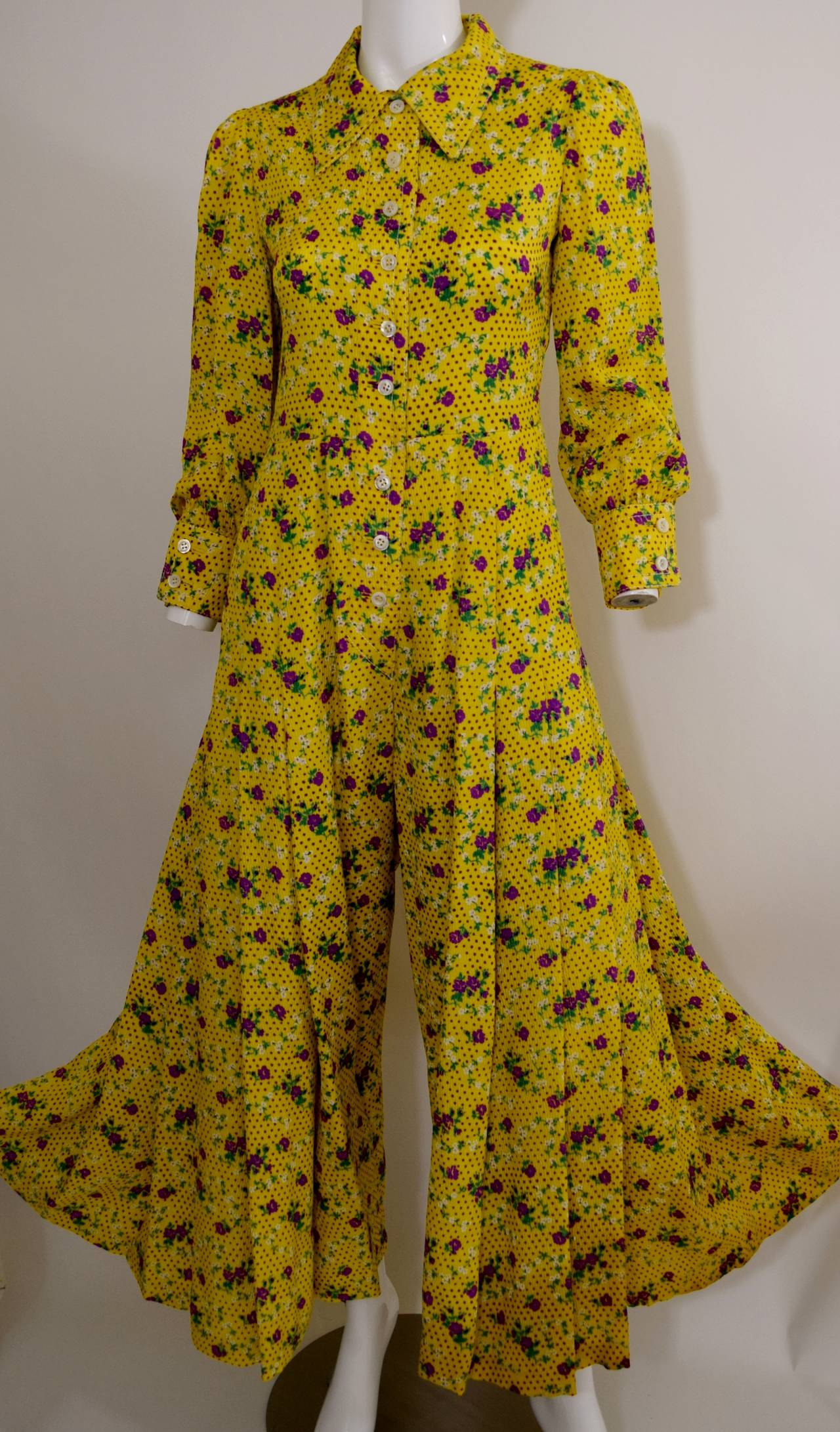 A fantastic Galanos 1970s yellow floral printed silk jumpsuit. The label has fallen out, guaranteed a Galanos, sold a dress with the Galanos label in the same print.
Long sleeves. button front. pointed collar. wide leg.
Excellent