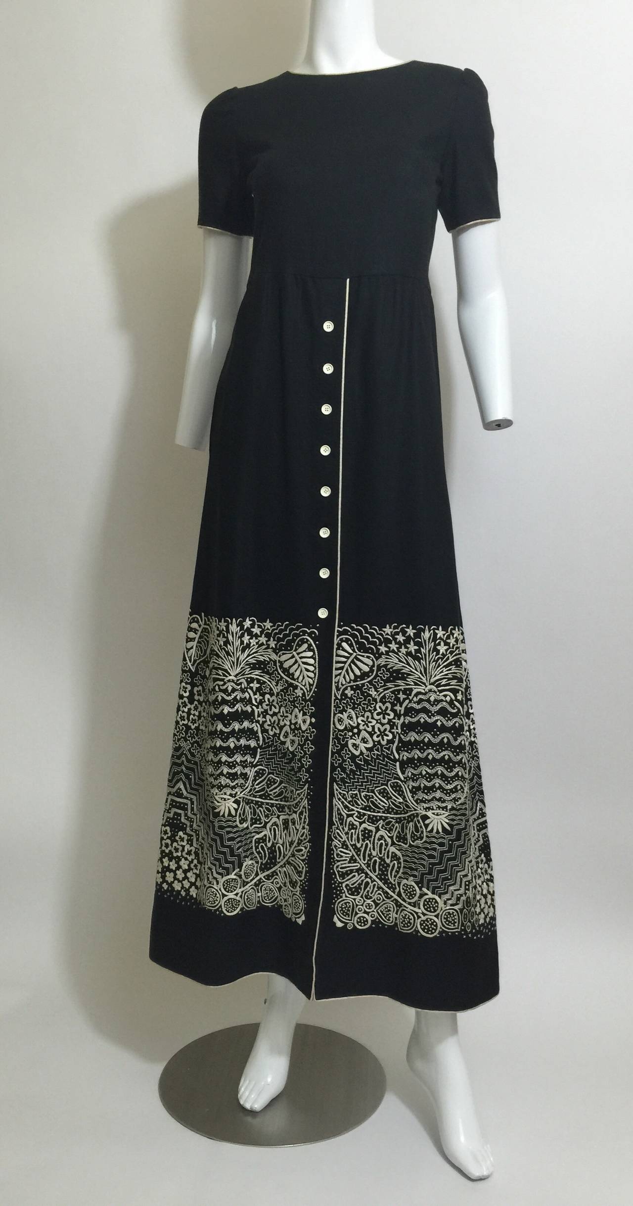 This dress is as impeccable today as it was 50 years ago. The fabric is a black linen with ecru linen piping trimming the neck sleeves and hem line. I am loving the beautiful embroidery work on the skirt portion with a pineapple floral motif. This