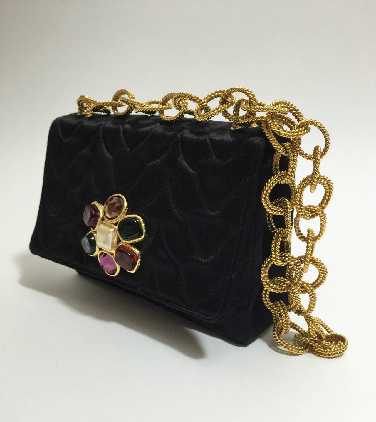 A rare Chanel Gripoix  collectable satin evening bag From the early 1990s. The chain  strap is made of doubled circle and oval links, each link is in a rope motif in  gold. The front of the purse has a gripoix adornemnet, in the colors of amber,