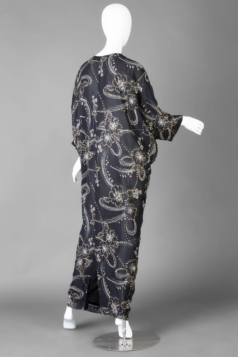 Lucie Ann Beverly Hills caftan.  Beautiful gold glitter and hand painted floral cocoon cut caftan. Sheer black chiffon double layer with a keyhole front bodice neckline. Dolman sleeves.
Best fit for a medium or large.
48