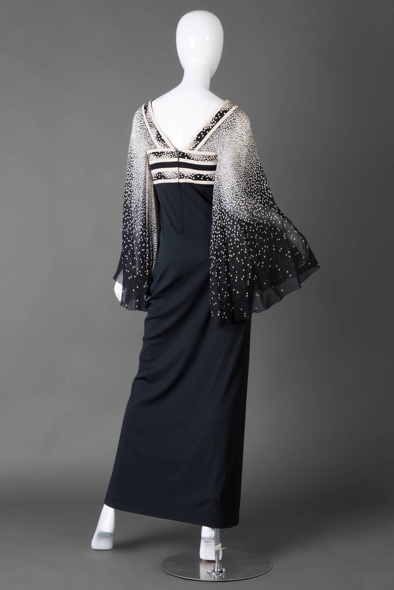 A flurry of mini white polka dots tumbles down onto dramatic black angel sleeves in this wonderful Leonard Paris dress from the Seventies. Cut from silk chiffon, the sleeves are sheer and lightweight to lend gorgeous movement to the long silhouette.