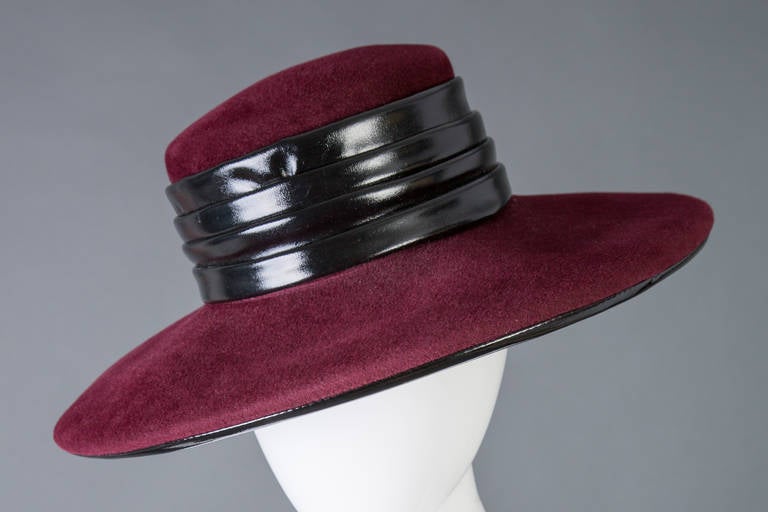 Elegant and Halston hat in burgundy wool felt with patent  trim. Around the crown is pleated black patent and the brim is piped as well. 1970s.
Excellent condtion
15