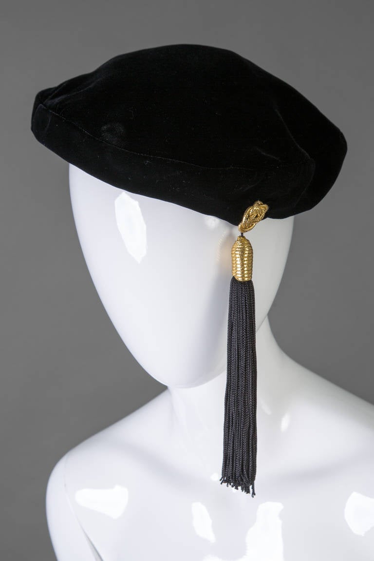 Yves Saint Laurent Black velvet beret with a tassel that measures seven inches in length. gold detail at the top of the tassel.
Measures about 21 inches around.