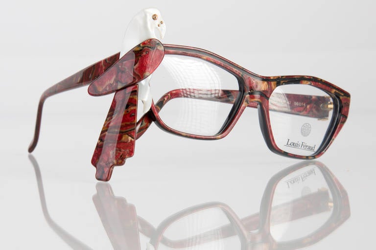 Collectable,  Louis Feraud  Parrot Glasses Frames. These frames are in a Marble Burgundy color and have a modified cat eye shape that  can be worn with or without the removable parrot, which is secured in place with two small screws. These frames