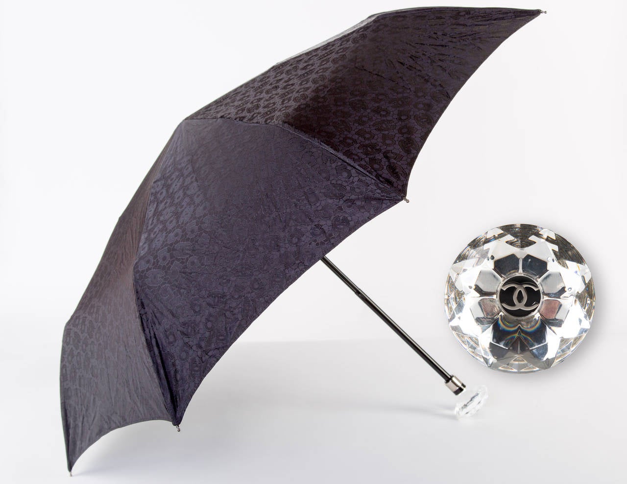 Chanel umbrella with a beautiful faceted crystal like base featuring the CC logo.
 The top of the umbrella is black with black on black CC's and 5 as the print.
 Excellent condition. Comes with Chanel umbrella case as shown in the photos.