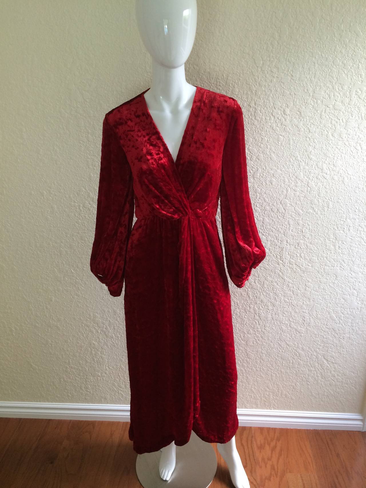 Stunning Saint Laurent Red Hostess gown or dress by Yves saint Laurent.
The fabric is a red crushed velvet, with gorgeous  drape. The front closes by crossing over and is secured by interior clasps. The sleeves are full and billowy with elastic at