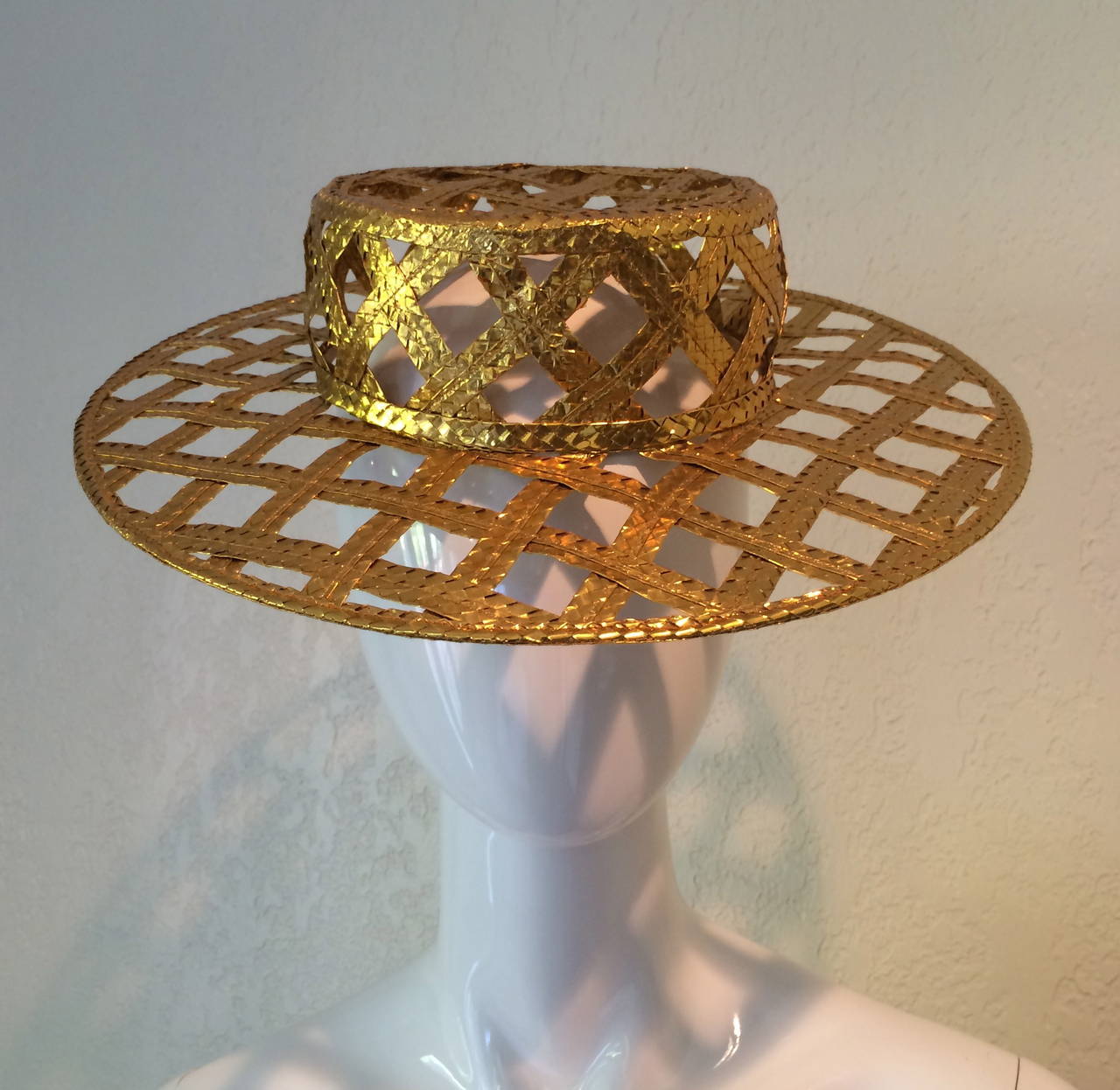 New with tags. Fabulous Chanel gold  lattice hat. The gold is woven and ultra shiny with a foil effect. From Spring of 1990.  Purchased from the West Palm Beach Chanel Boutique over 23 years ago. Please see last photo for the Chanel advertisement 