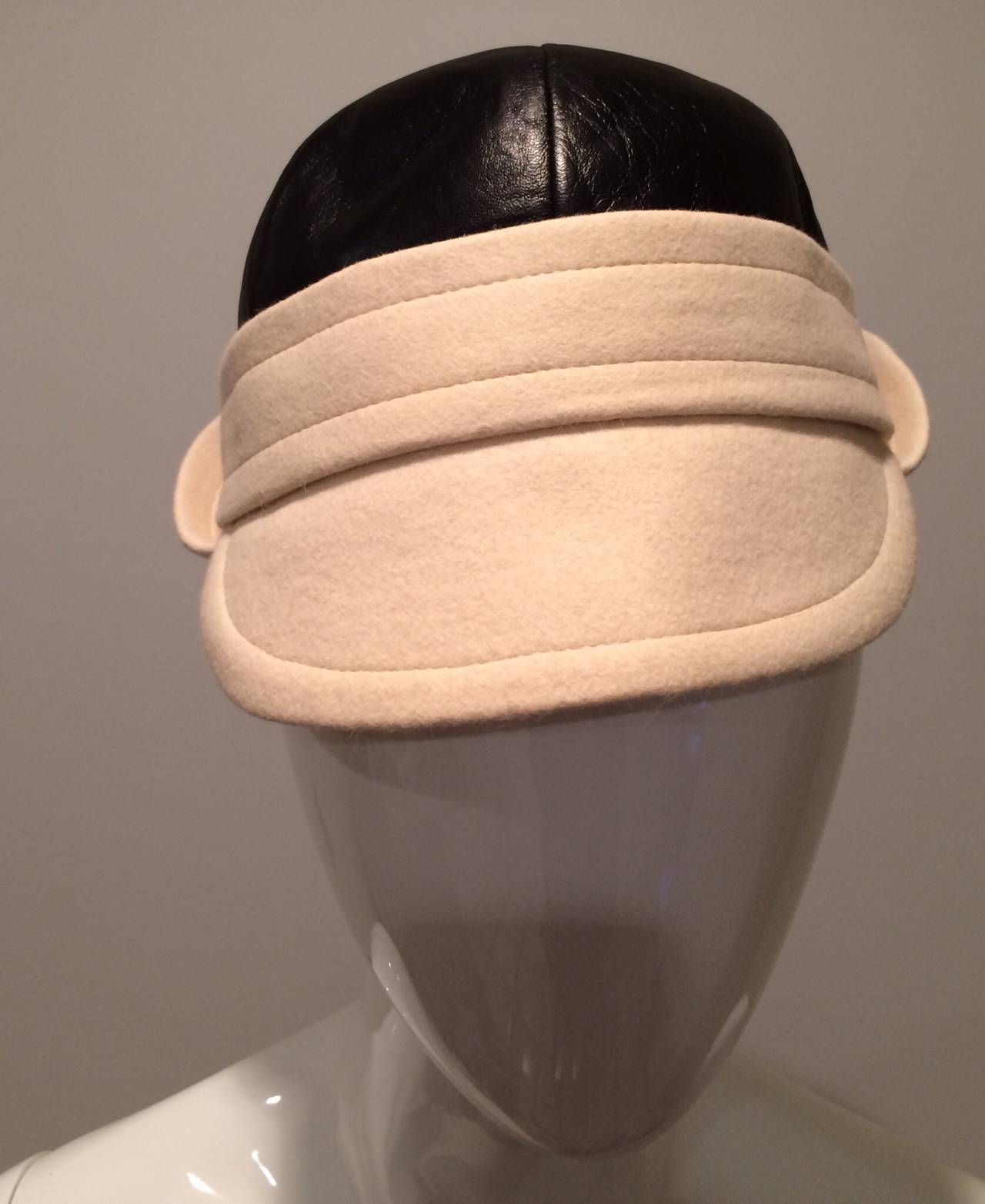 This Yves Saint Laurent hat is new old stock with  store tags. It is black leather and ivory felt. Best for a size small. 20