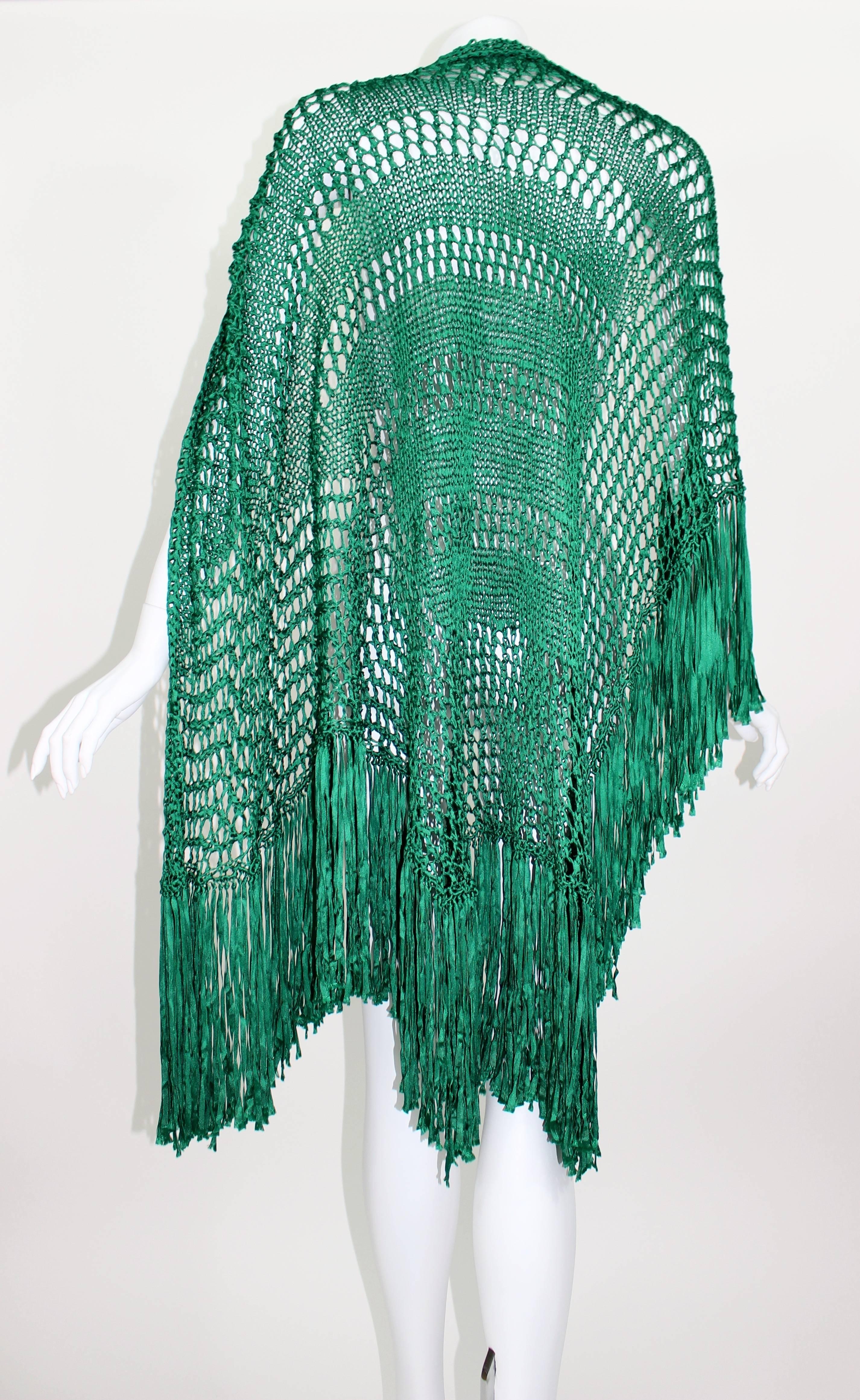 An exquisite vivid emerald green handmade shawl with long fringe trim.
Feels like silk. 
Handmade
Triangle shape.

Measurements.
Width: 60" inches excluding fringe.
Fringe: 9.5 - 10 inches long
Length: 48 inches (including fringe)