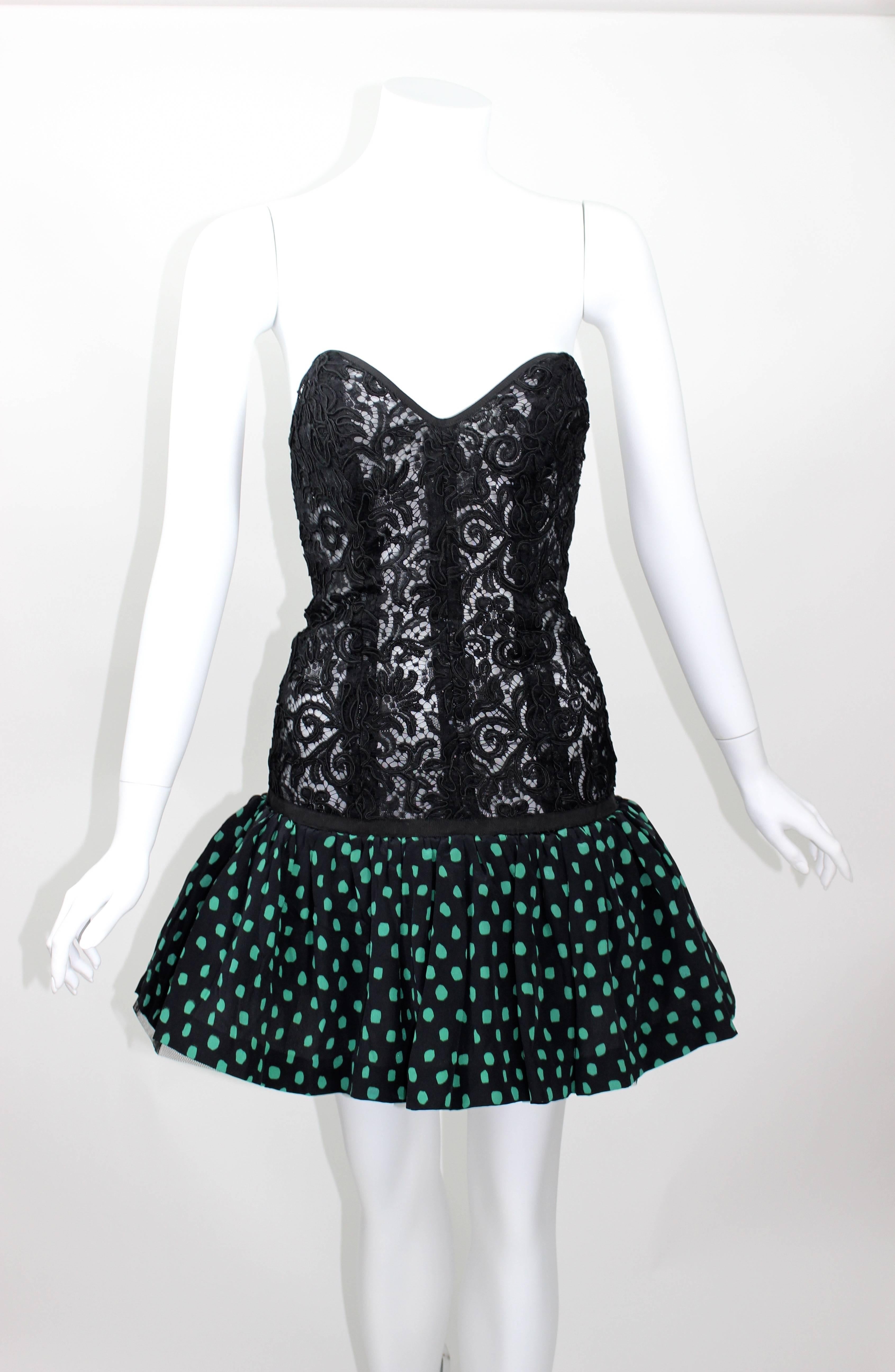 A boned corset body in black guipure lace.
A  tulle and silk pouf skirt in black silk with green polka dots.
Side zipper closure for ease of access.
In excellent condition.

Measurements:
Bust: 32 inches
Waist: 26 inches
Hips: 36