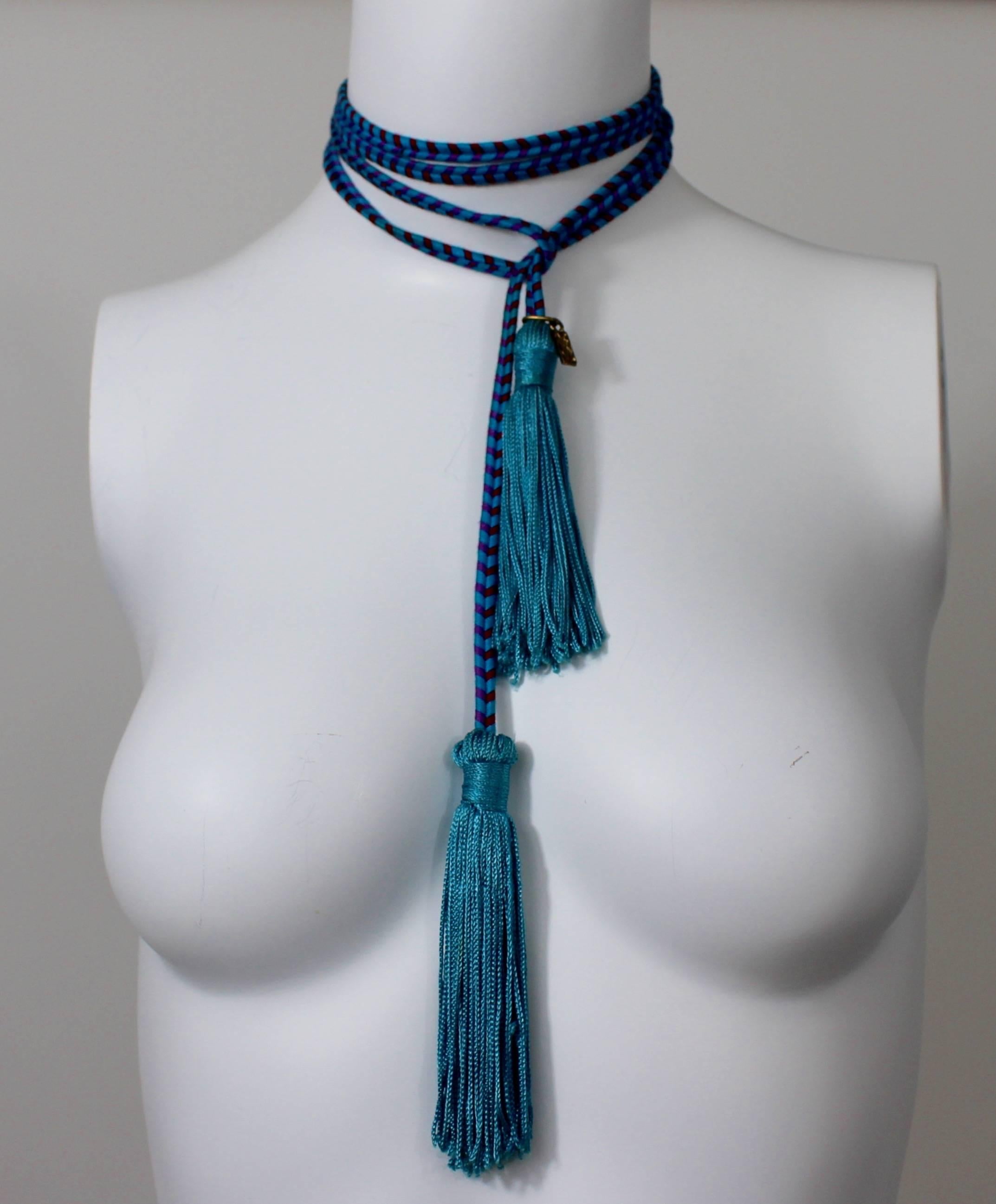 Turquoise blue with red and purple accents throughout. Over four inches of turquoise tassel fringe on each end. 

Size estimate: One size fits most
Measurements:
Length: 63 inches
Tassels: 4.5 inches
