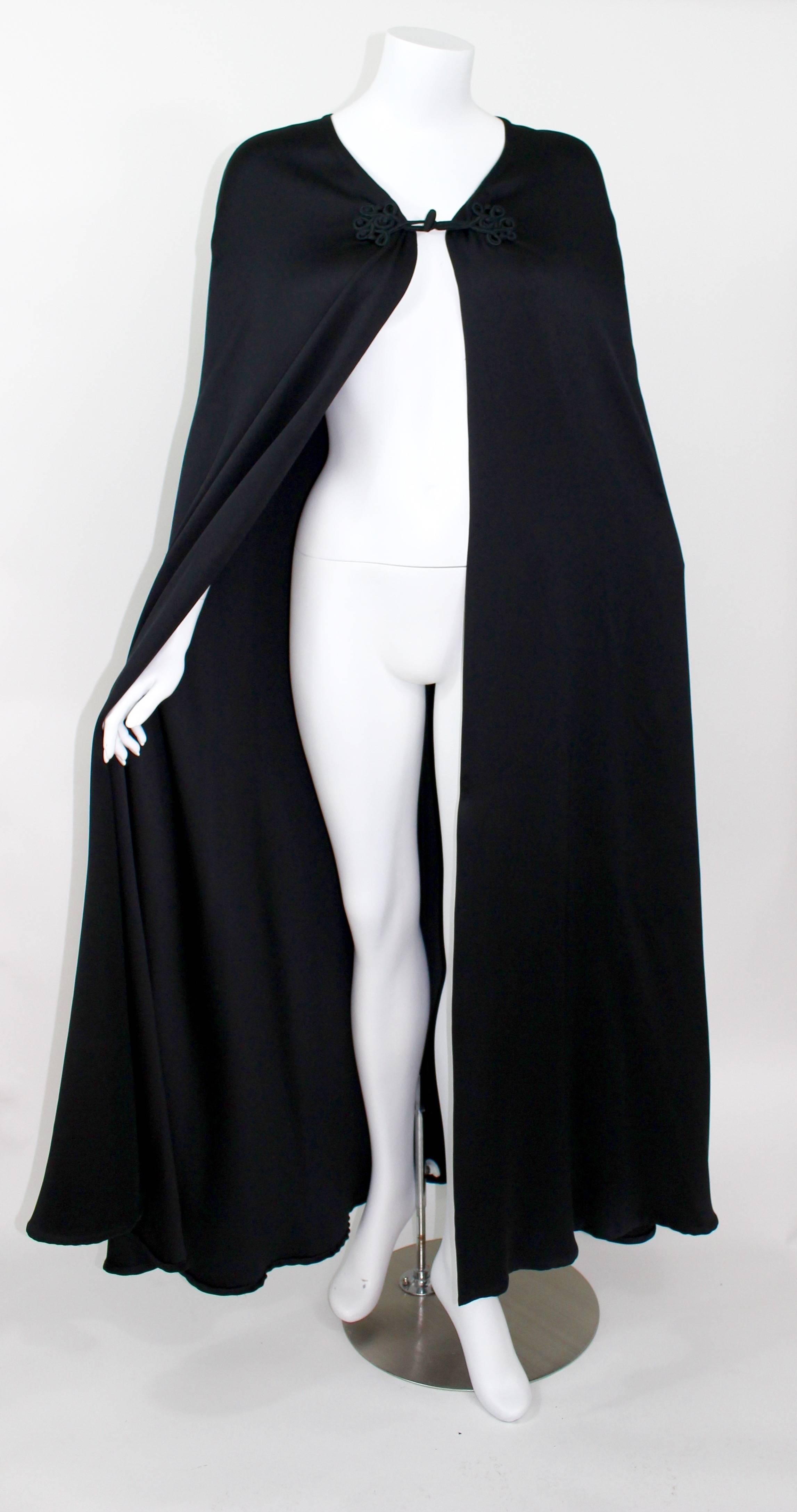 A Valentino Couture vintage cape. 
Circa late 1970s.
The jet black satin is extremely smooth and of superior quality.
Embroidered toggle closures are hand sewn.
The hem and frame of the cape are finished to perfection.

In Excellent condition aside