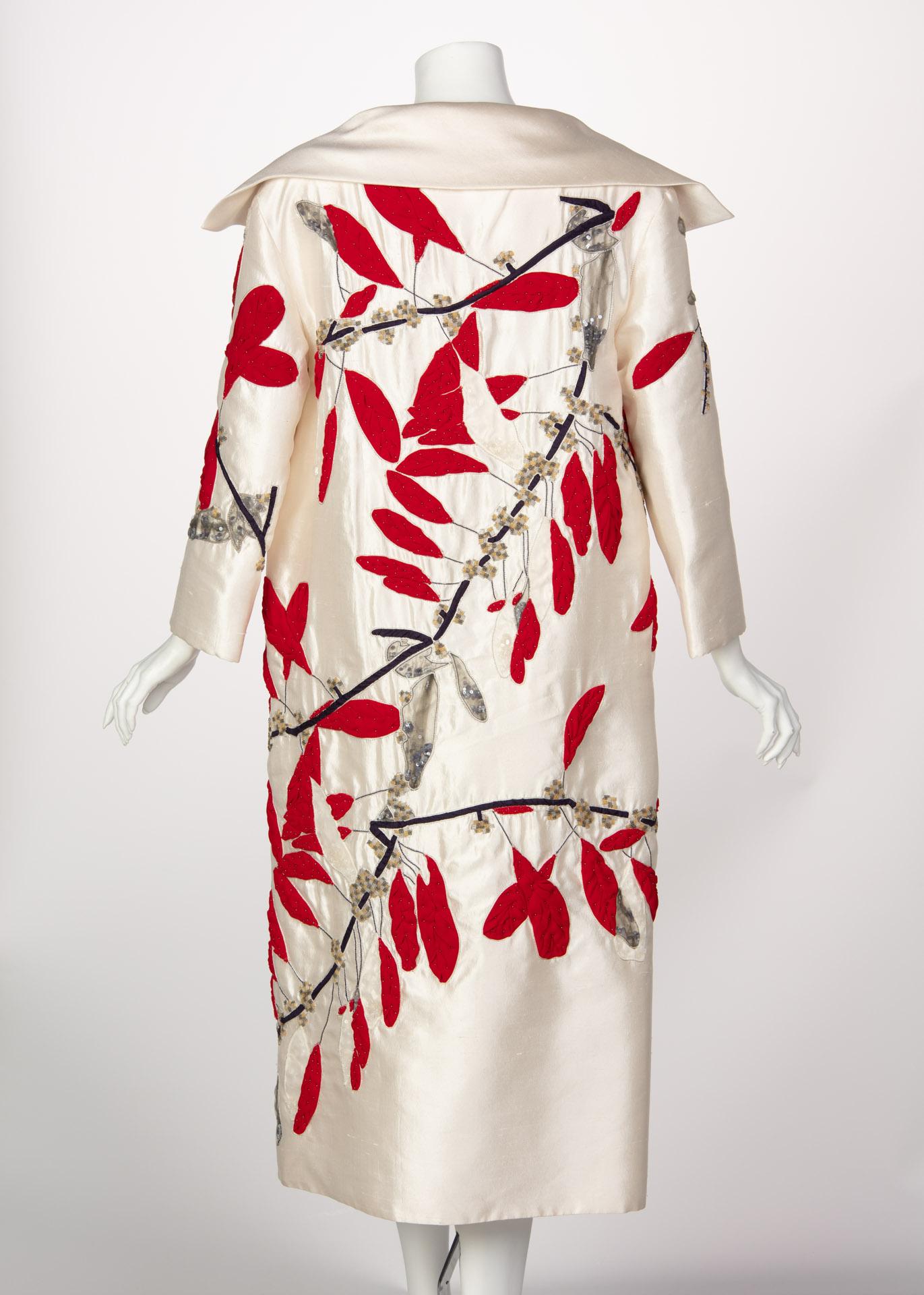 An Exquisite Ivory silk Valentino long evening coat with embroidered and beaded branches and leaves motif  throughout.
The leaves are sculpted from red silk and sewn on by hand, each leave is detailed with beading and framed with silver metal