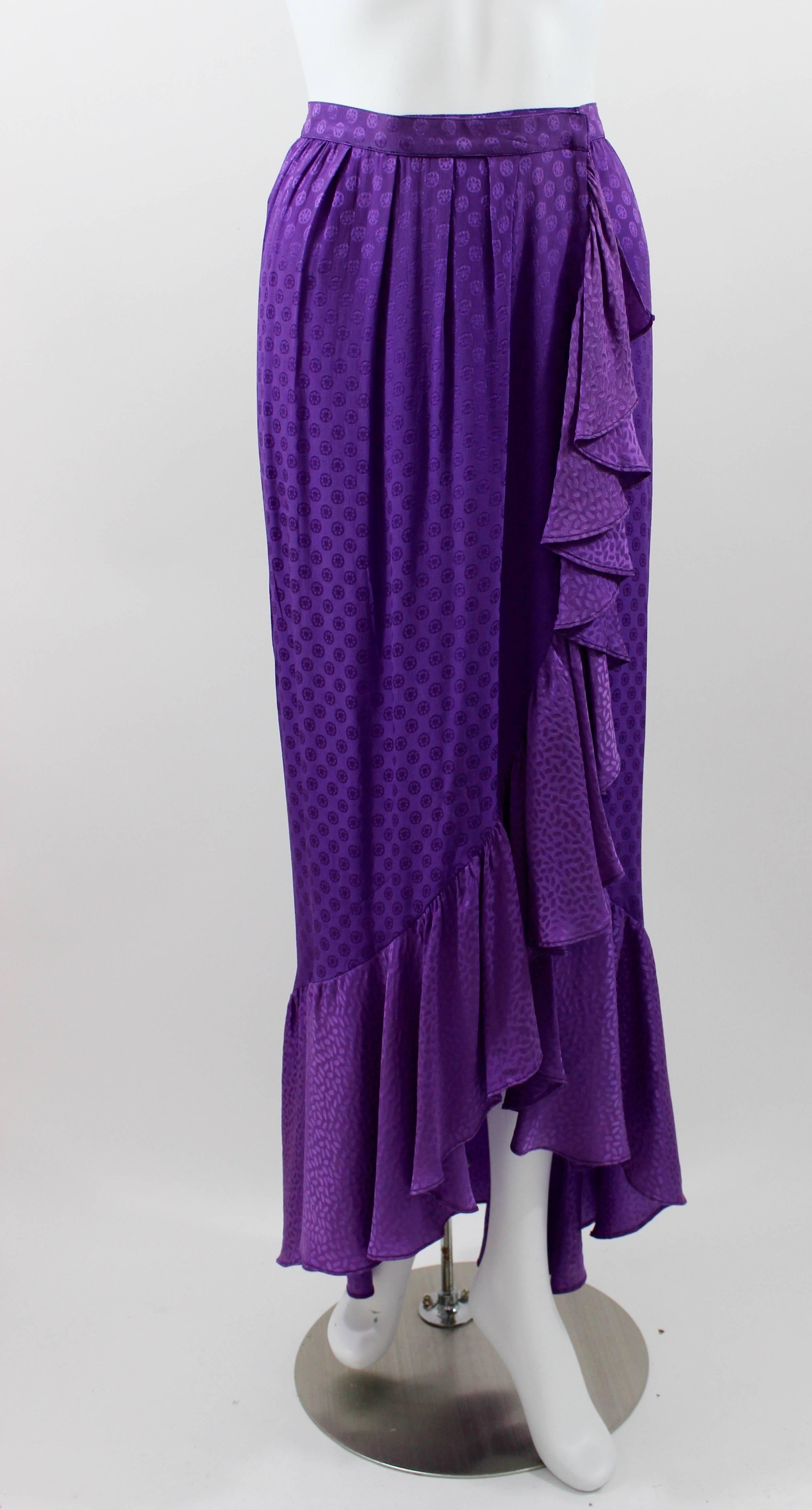Purple Silk skirt. Ruffle trim.
Wrap style skirt.
Hidden hook closures in the waistband.
Discoloration at the bottom of the ruffle, partially hidden in the ruffle pleats, please refer to images 5,7 and 8 for details.

Size estimate: S

