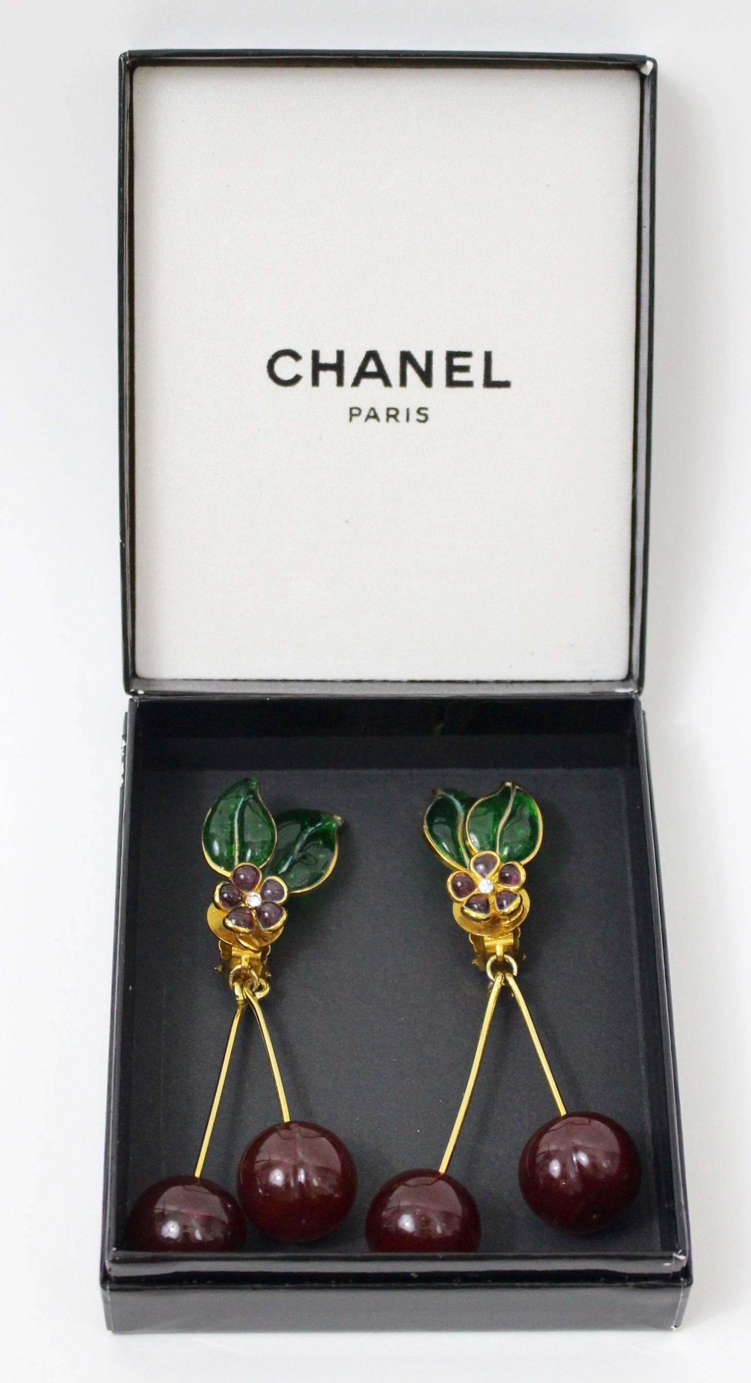 A magnificent pair of  Pate de Verre cherry earrings by Maison Gripoix for Chanel. Emerald green hand poured glass leaves and gold toned veins. Amethyst glass flowers with crystal paste centers and long dangling glass cherries.
These very rare