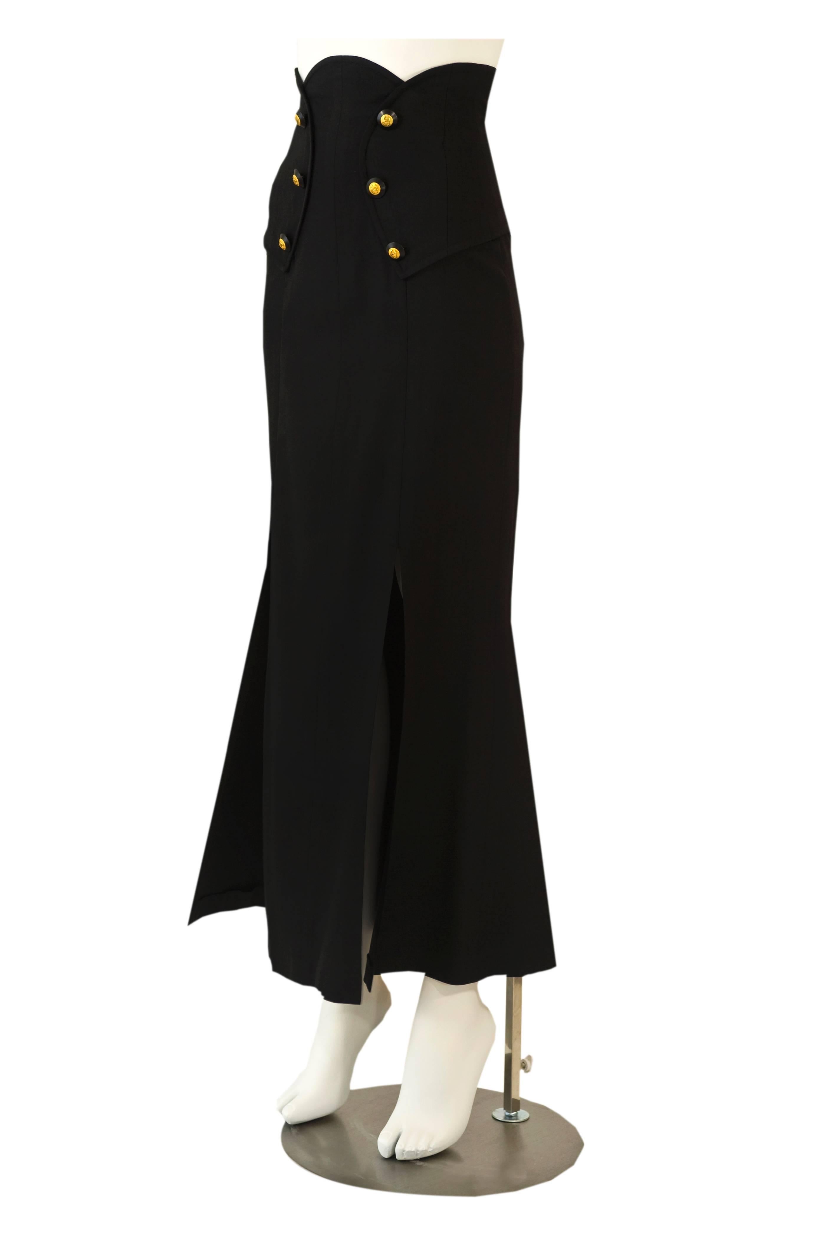This is a fantastic  vintage Chanel skirt  that will never go out of style.  Done in a fine  black medium to lightweight wool with a beautiful sculptural panel that curves around  the waistline. There are six black buttons with the golden
