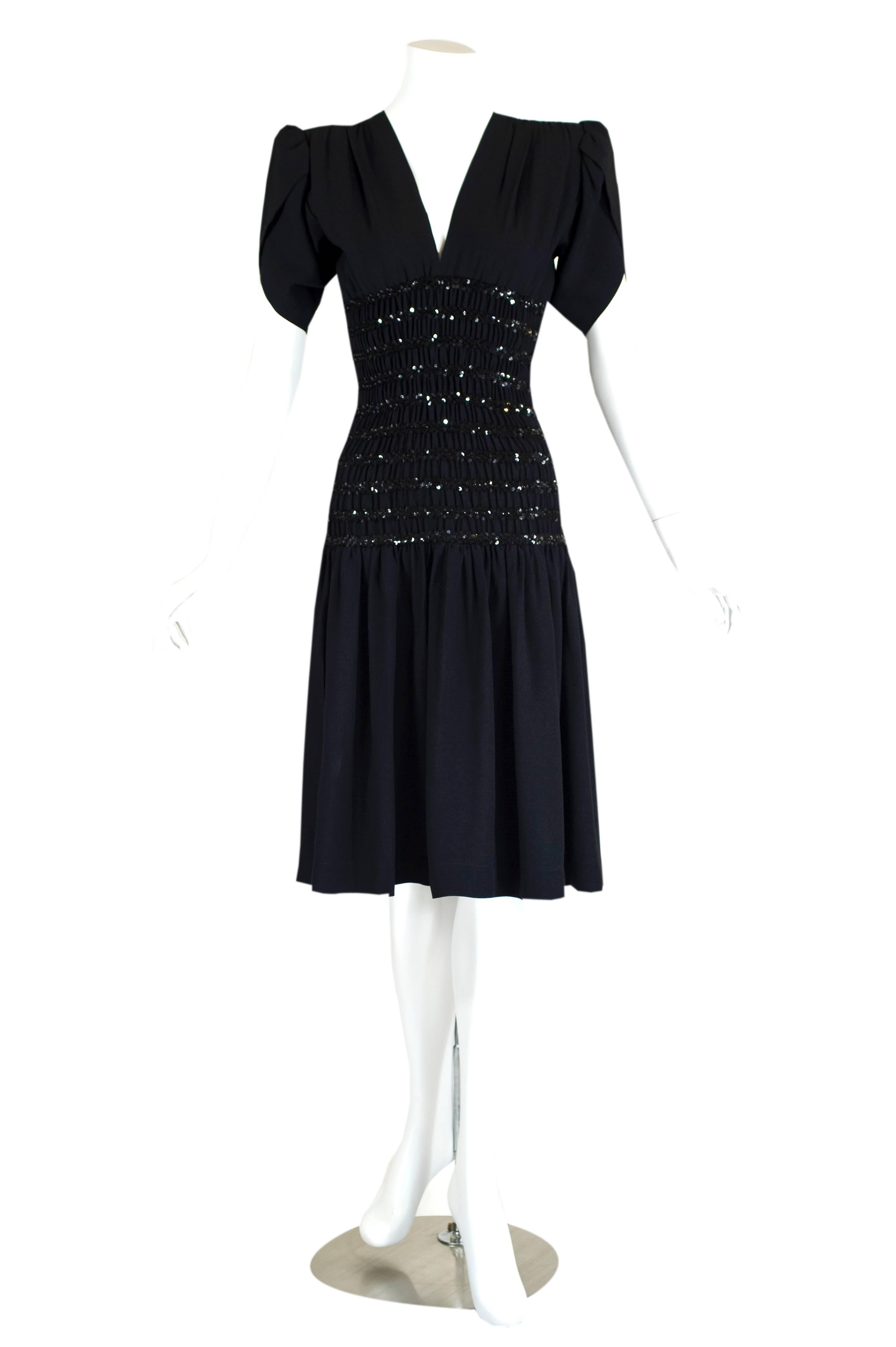 From the Eighties, this crepe de chine cocktail dress by Yves Saint Laurent shows how power shoulders and sequins can look downright stunning in the capable hands of a masterful designer. The padded supports form a gorgeous line at the top of the