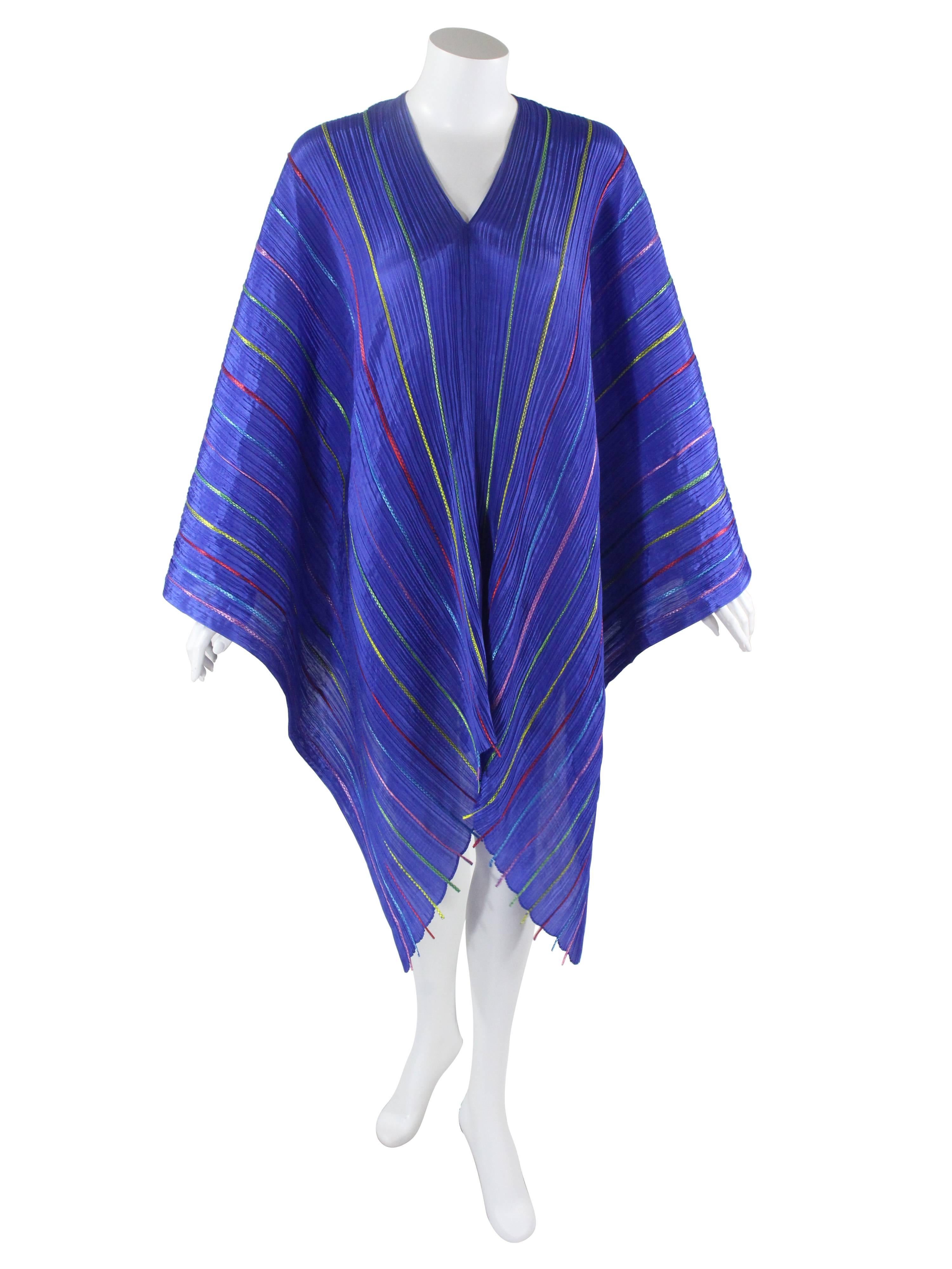 This is an incredible sculptural piece  by Issey Miyake  Pleats Please. Wear it as a cape or dress!  Made of Issey Miyake's signature pleated polyester fabric in royal blue with a rainbow set of ribbon applique. This drapes beautifully on the body,