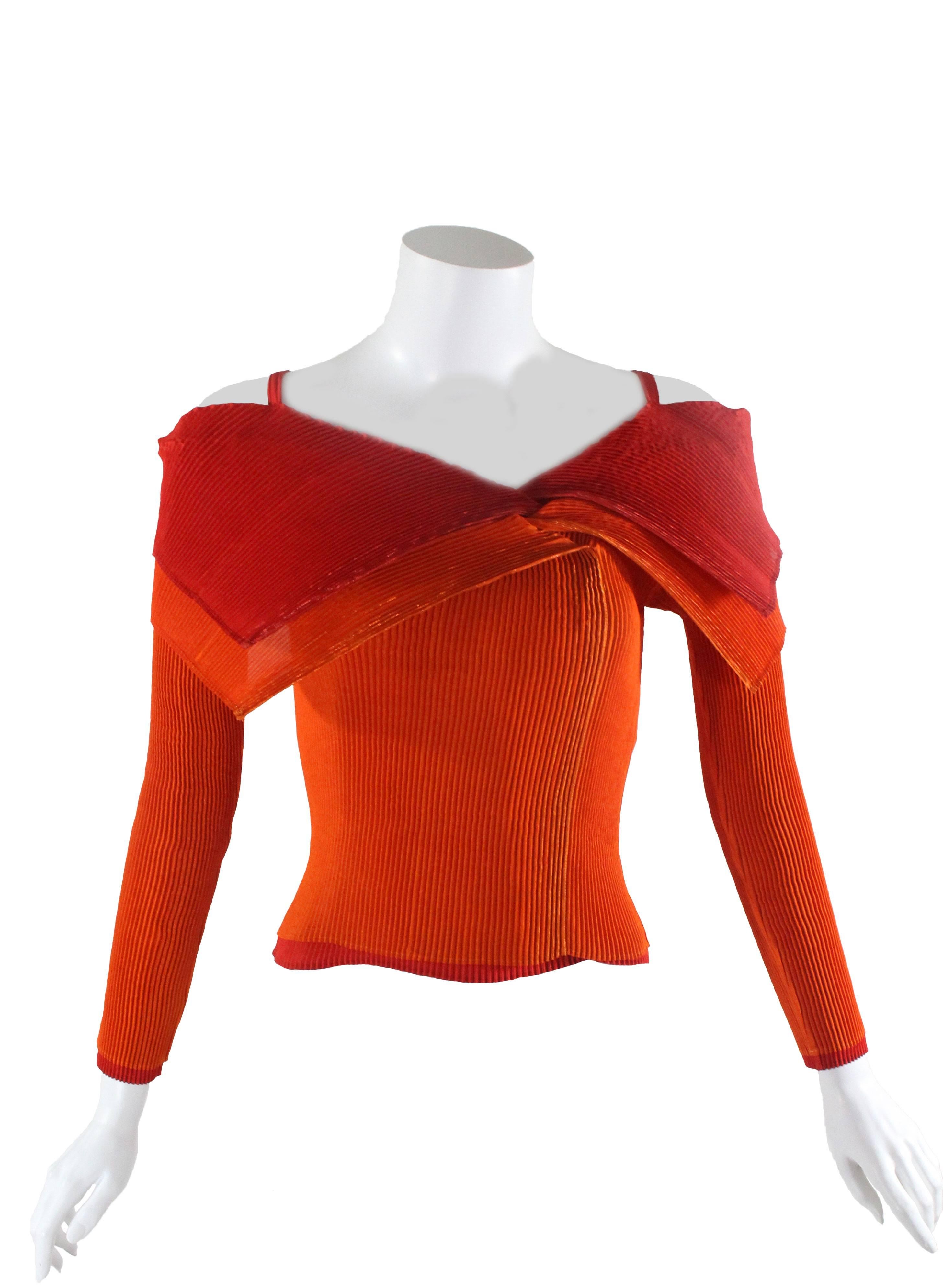 A fabulous sculptural top from Issey Miyake circa 1990. Fashioned from Issey Miyake's signature vertical pleated fabric in a double layer with red on the inside and orange on the exterior. The vivid red and orange fabrics have a subtle metallic