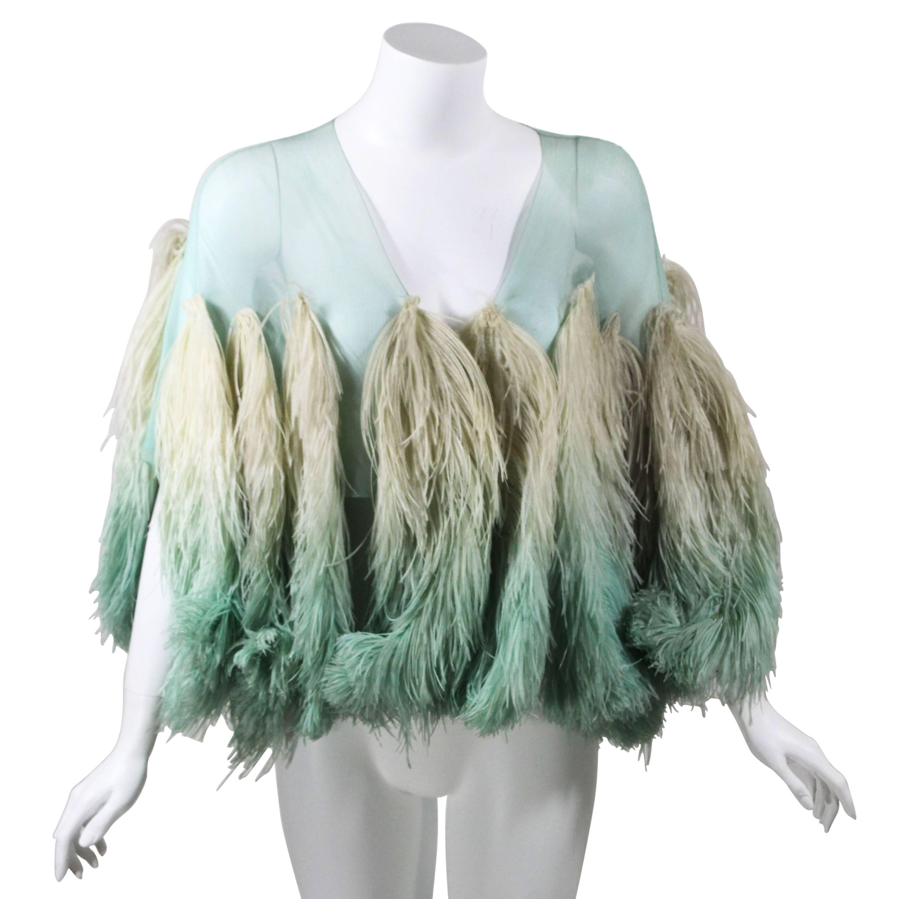 A breathtaking cape done in  a fine  silk georgette in the  stunning color of  aquamarine blue/green, possibly hand dyed. Sixteen ombre ostrich feathers from beige to aquamarine are hand sewn on the silk base to create this sensational wrap. The
