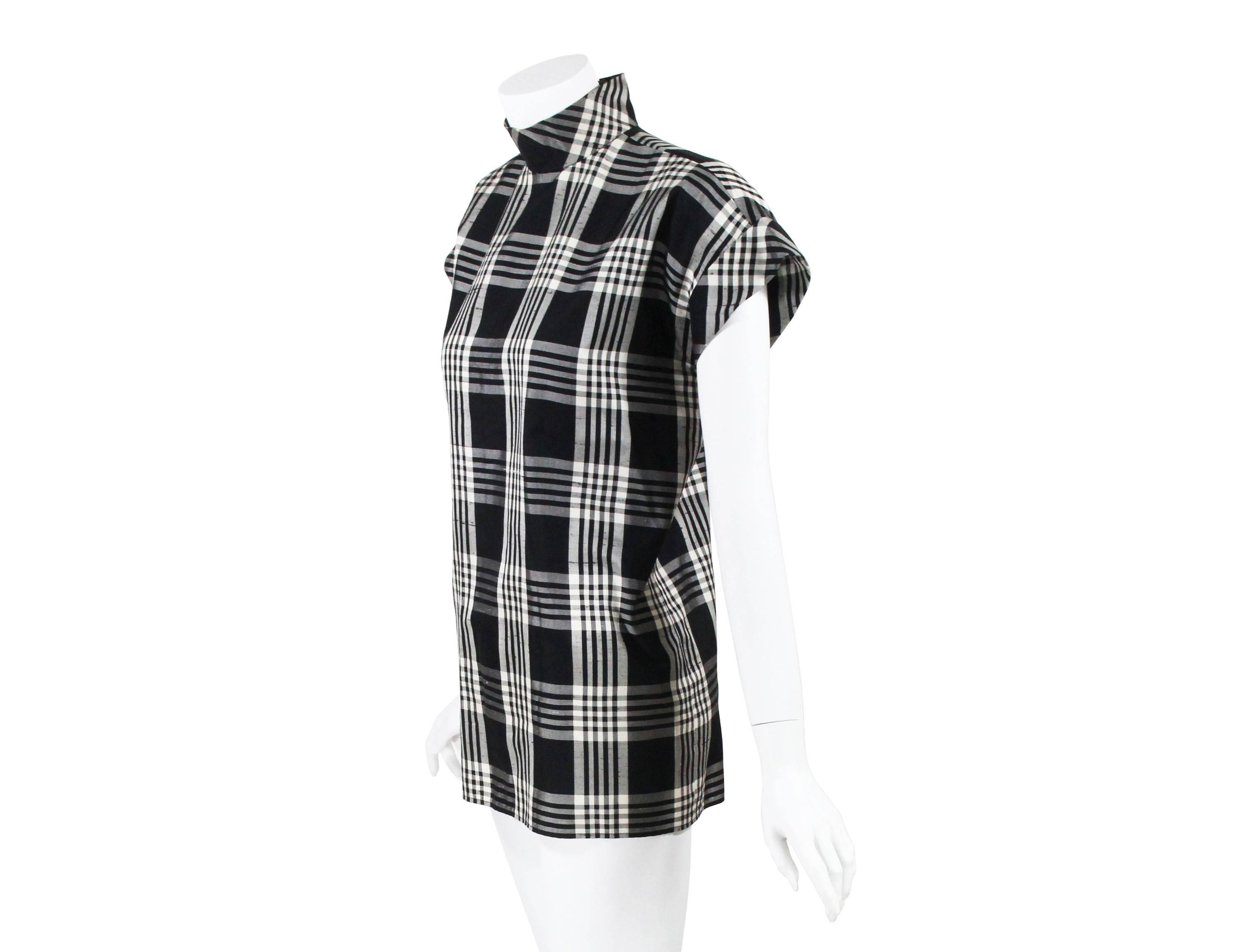 A very rare vintage Chanel numbered haute couture blouse top. Done in the finest raw silk in classic  black and off white plaid. Boasting impeccable  cut and exceptional tailoring this masterpiece features a sophisticated high neck line with two