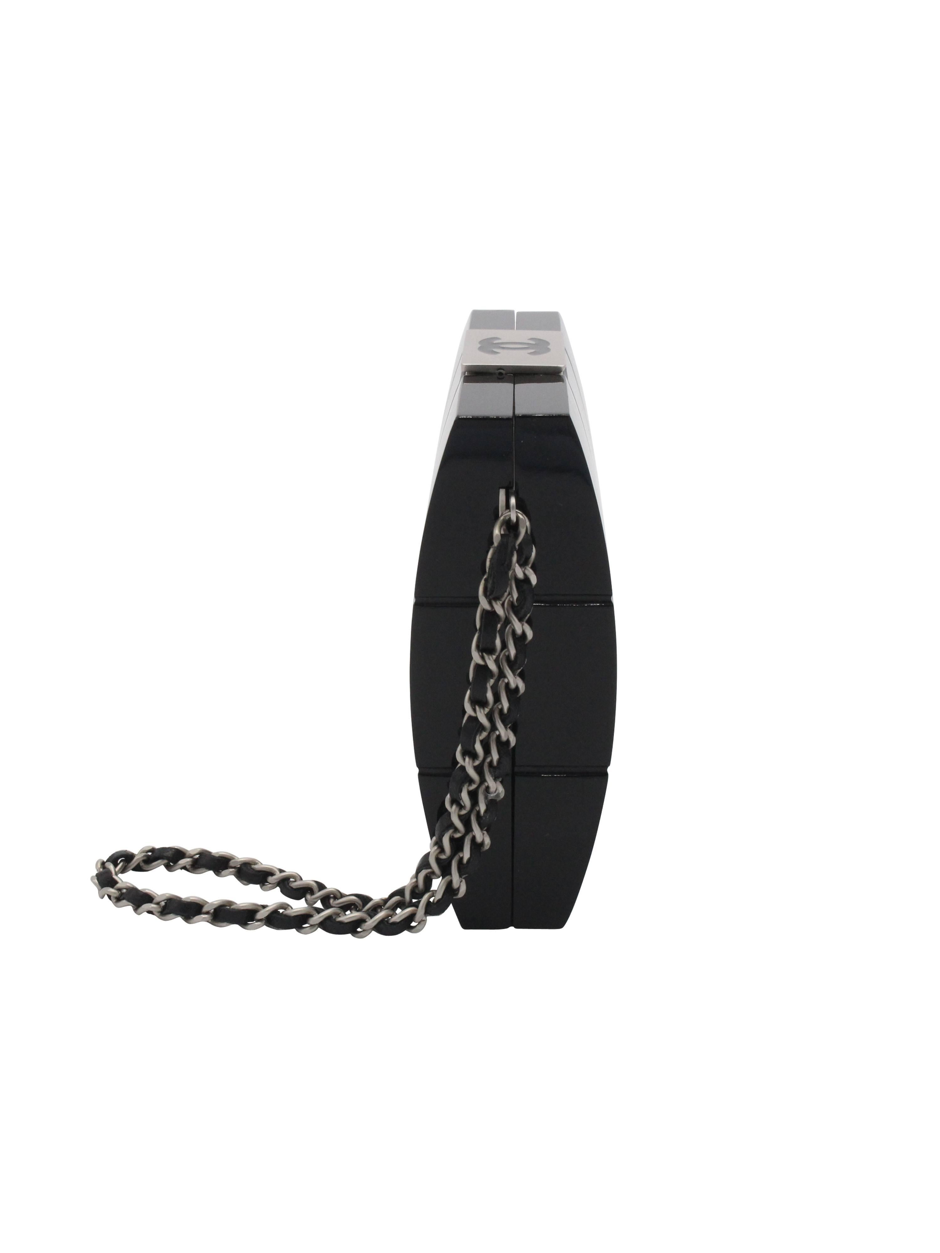 Schwarze Chanel Clutch aus Lucite mit matt silberfarbener Hardware, seitlichem Henkel aus Kette und geflochtenem Leder, ineinandergreifendem CC oben, durchgehendem Steppmotiv, einer einzelnen Innentasche und Druckknopfverschluss oben. Die
