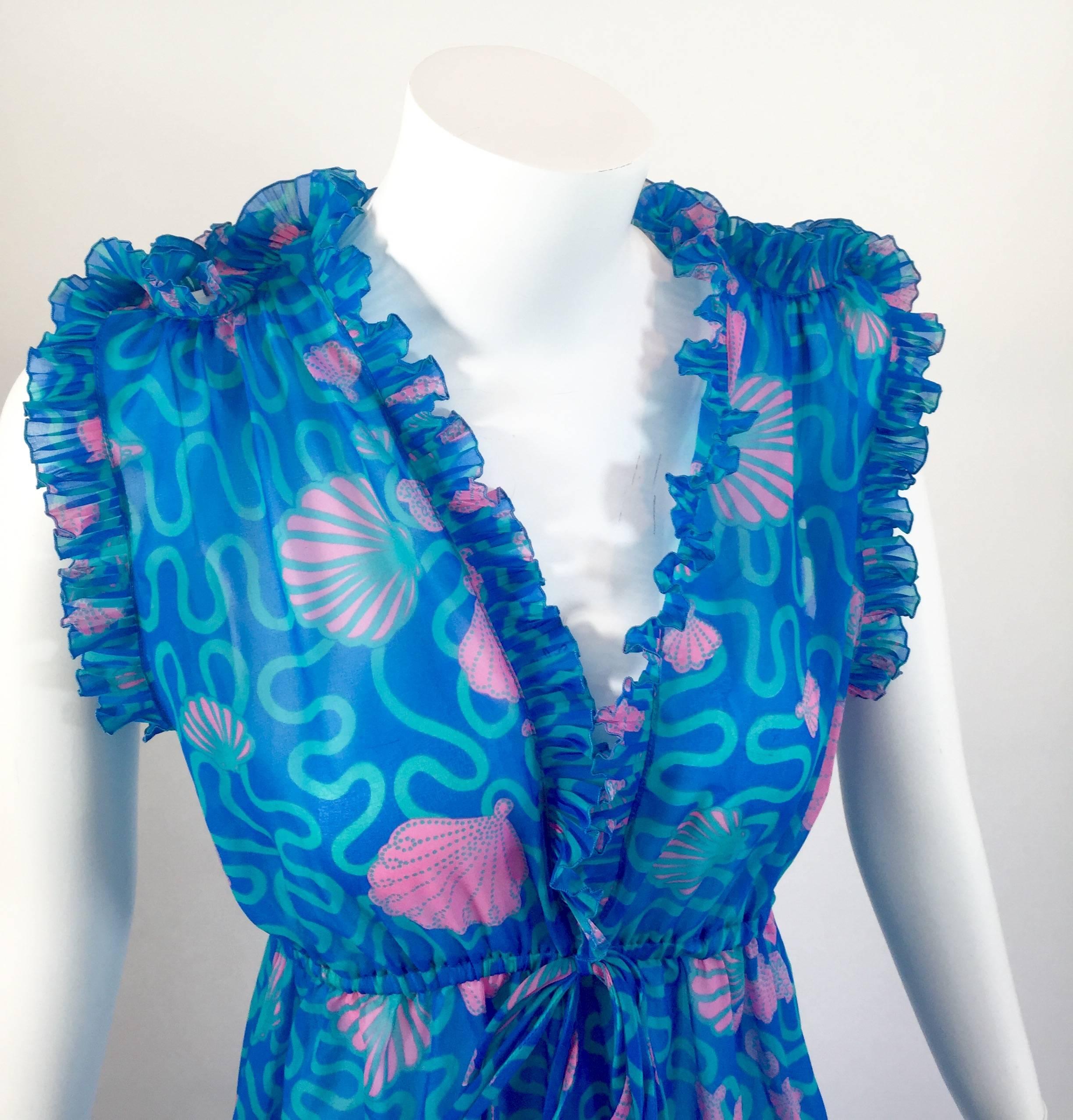 A  breathtaking vintage Zandra Rhodes signed seashell print caftan maxi dress. Done in an airy semi sheer soft and flowing poly chiffon. Featuring a stunning intricately ruffled accordion pleat plunge neckline, with cutouts on the shoulders