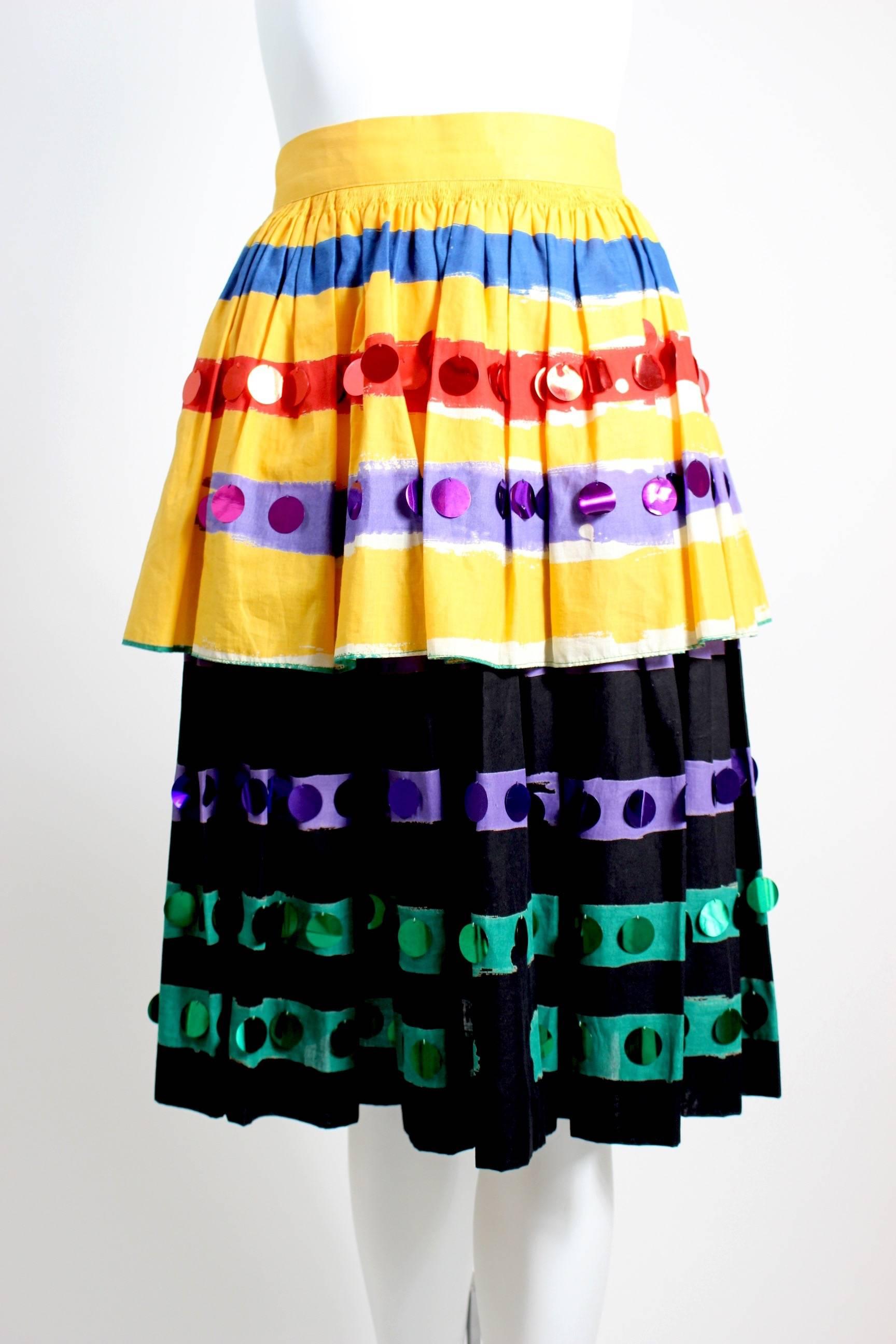 A fabulous and fun Michaele Vollbrach  1980s skirt. Done in a soft cotton the top layer is a bright canary yellow  with colorful brush strokes in blue, red and purple, the bottom layer is black with purple and green strokes. Large colorful metallic