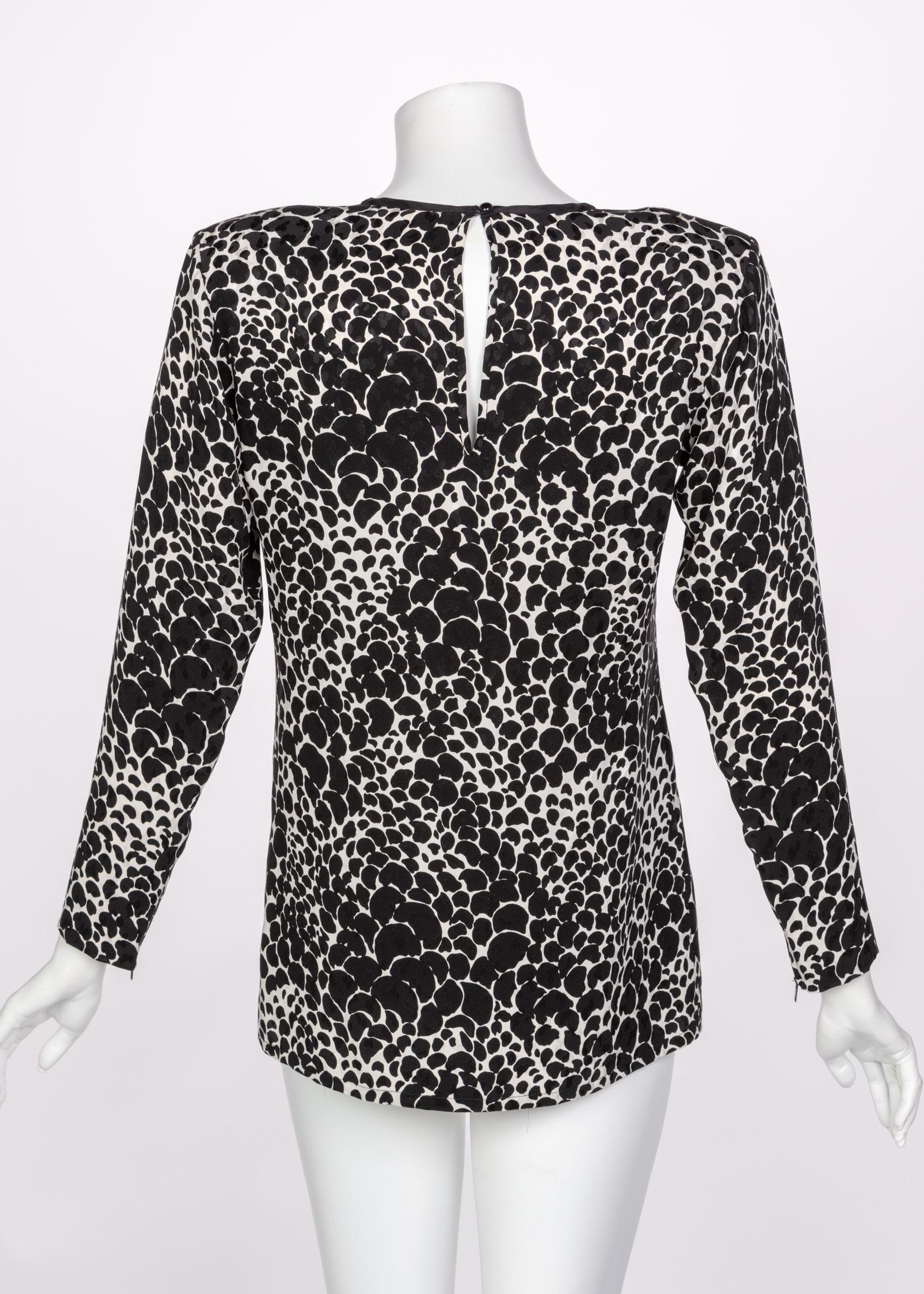 This 1970s Yves Saint Laurent blouse done in silk and covered in  black and white spotted print. Padded shoulders. Unlined this  blouse slips over the head  and closes closes at the neck with a round black plastic button. Professionally cleaned and