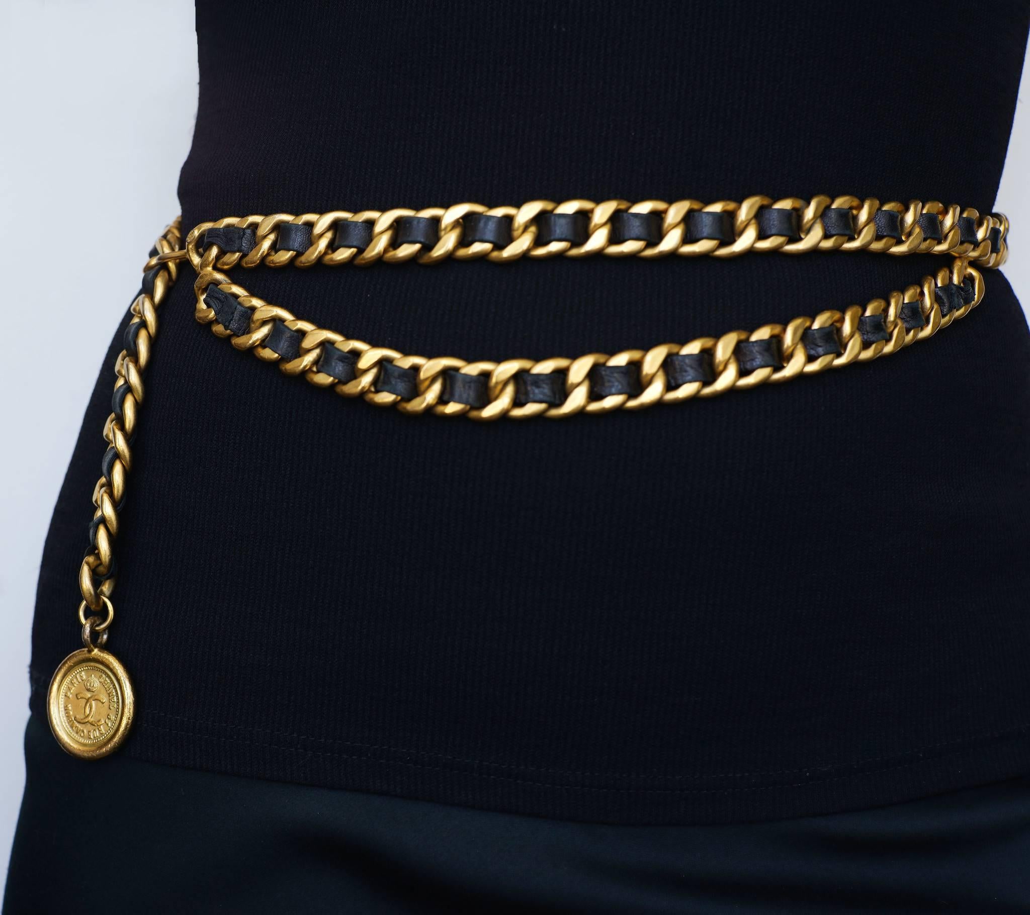 Chanel classic double chain belt with goldtone chain with leather woven through out the links and a Chanel medallion coin on the end.  

-Measurements-
length: 36"
Thickness: 1/2"

Good Vintage Condition:Please remember all clothes are