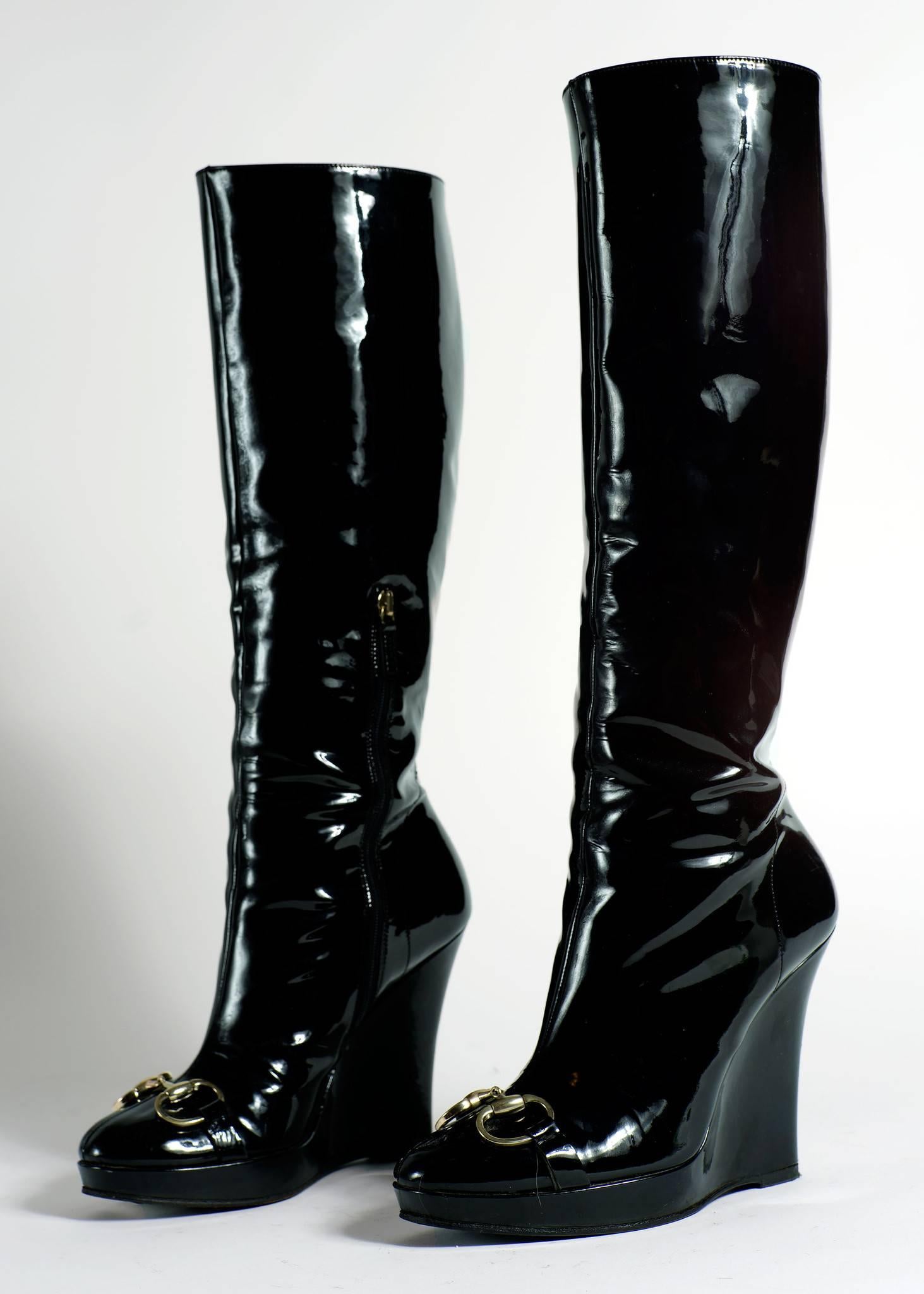 Black patent leather wedge heel boots with a gold horse bit detail by Gucci.

Color: Black 
Size Marked:  7 1/2B, 14 inches from heel and covers calf, Wedge is 4 inches 
Shipping Weight: 5lbs  

Good Vintage Condition: Please remember all clothes