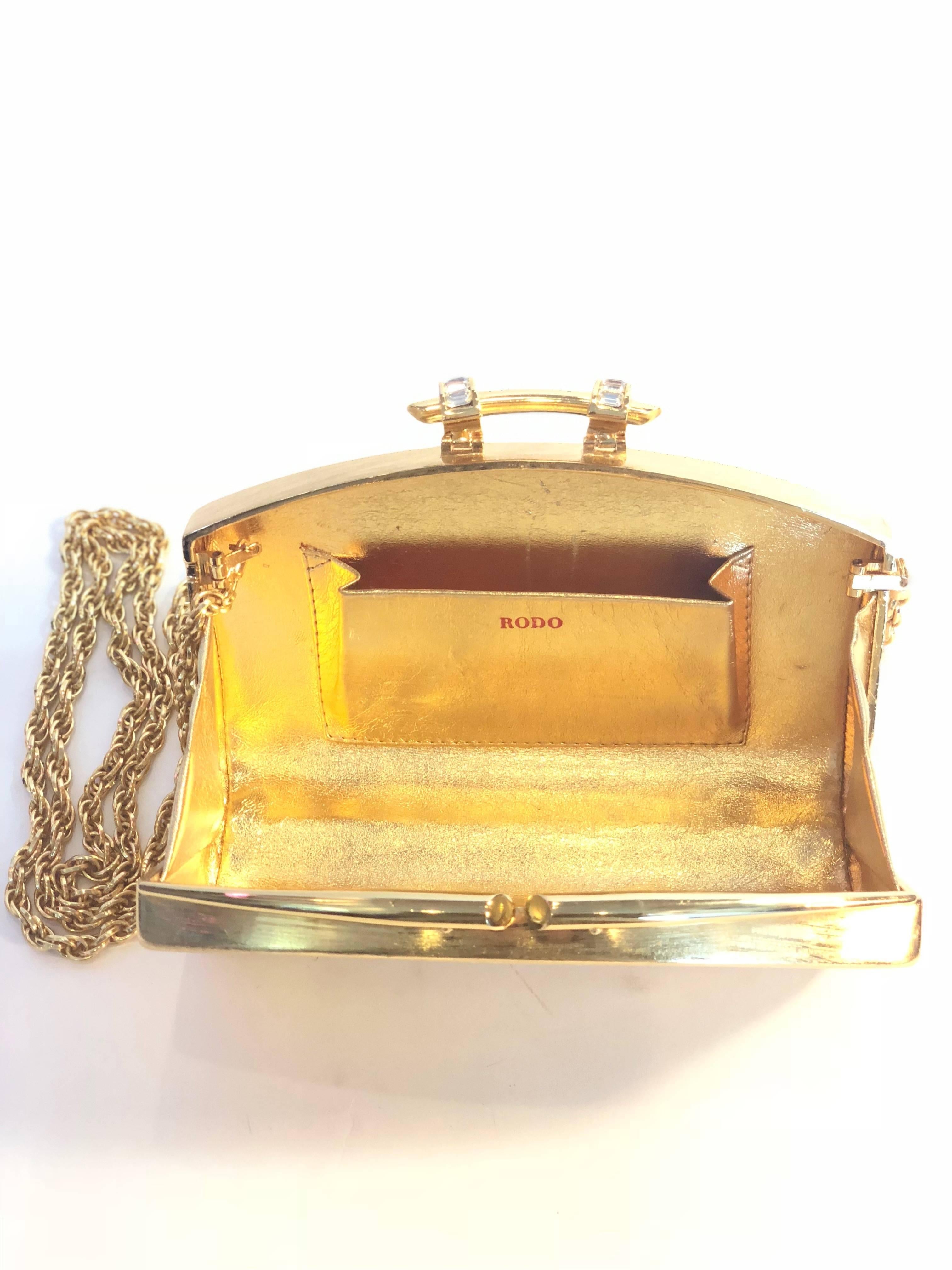 Rodo gold metal evening clutch, lined in gold leather. Converts into shoulder bag.
