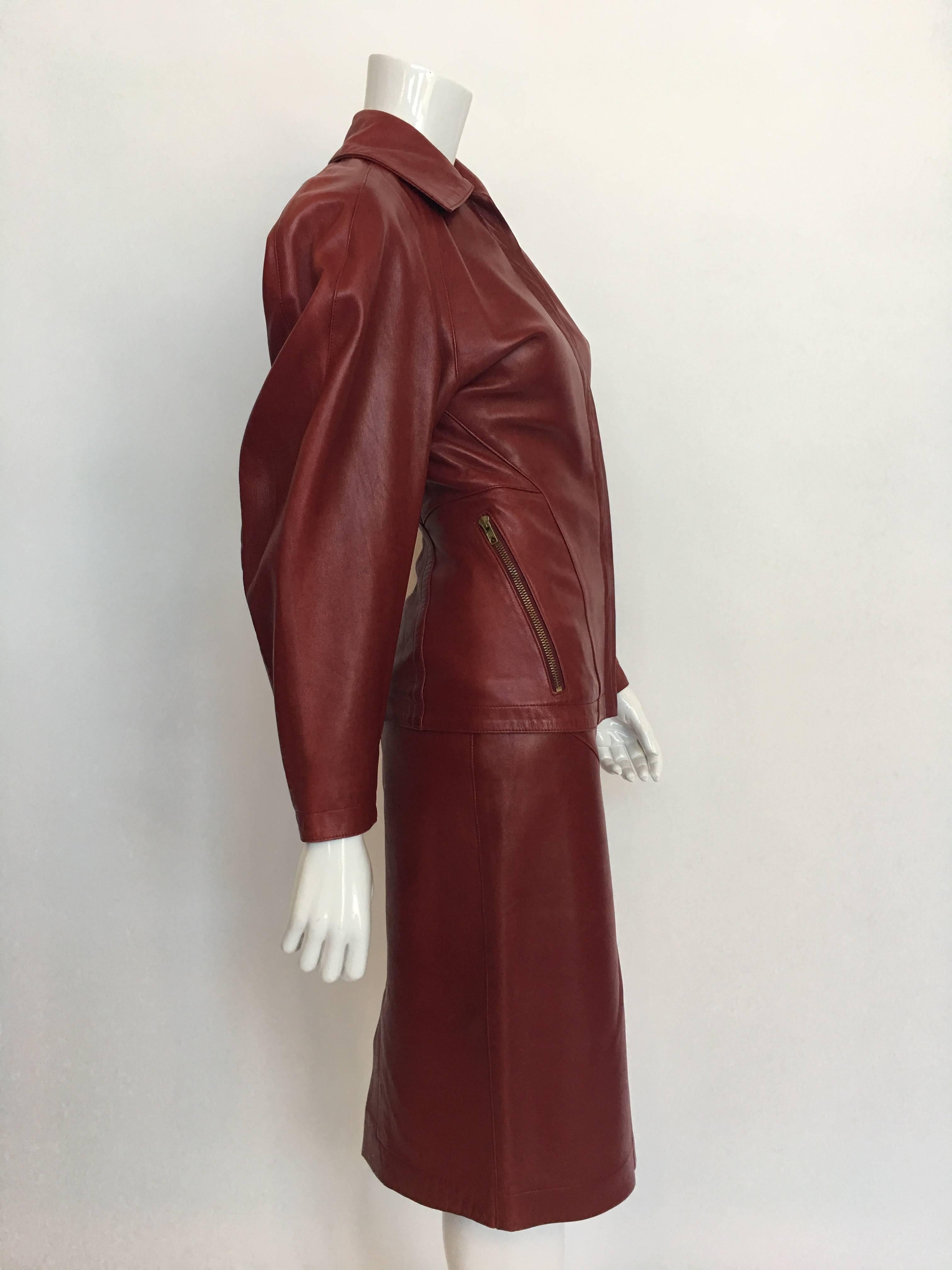 Combinaison jupe en cuir rouge Alaia 1980's avec 2 poches zippées sur le devant et plis inversés dans le dos.
La jupe est munie d'une fermeture à glissière et d'un bouton-pression et d'une aération au dos. La jupe est également entièrement doublée