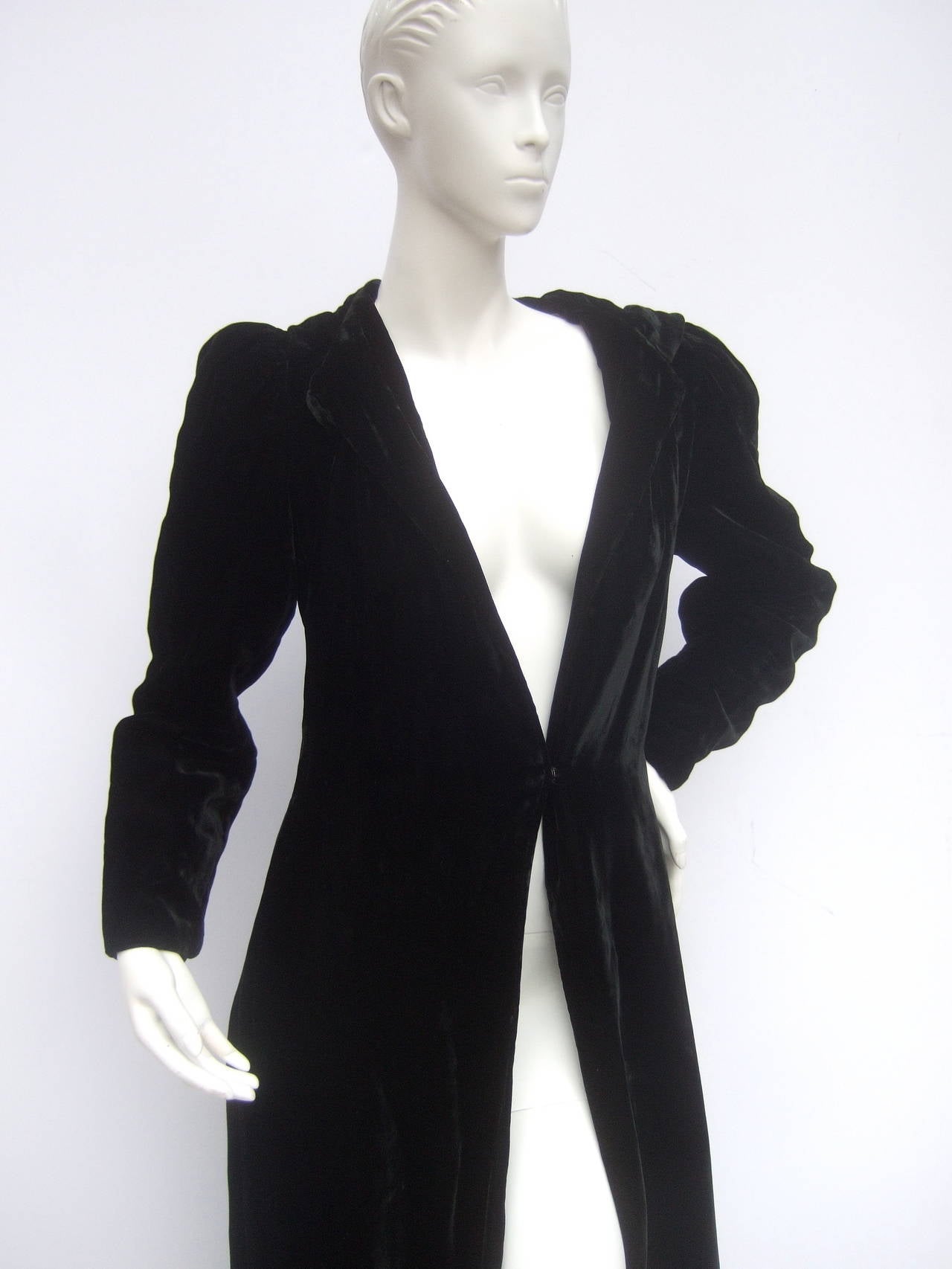 Dramatic black silk velvet hooded evening coat c 1960
The luxurious plush black velvet opera style coat makes a stunning garment 
The coat secures with a single large velvet covered button at the neckline 
Designed with one snap button at the