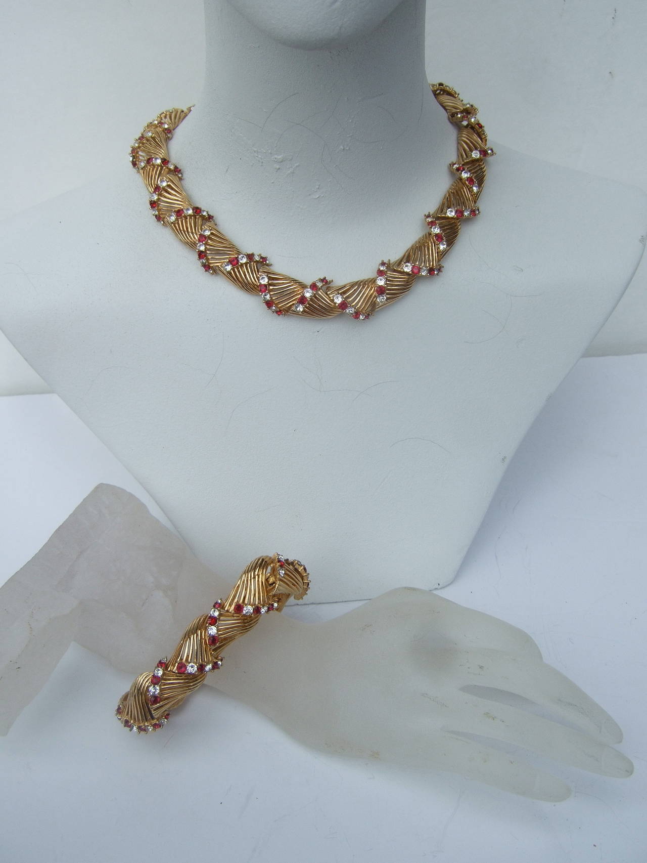 Marcel Boucher Elegant crystal wreath necklace & bracelet set ca 1960
The gilt metal necklace & bracelet are embellished with brilliant ruby color red crystals interspersed with diamante crystals. The glittering crystals are encrusted in the gilt