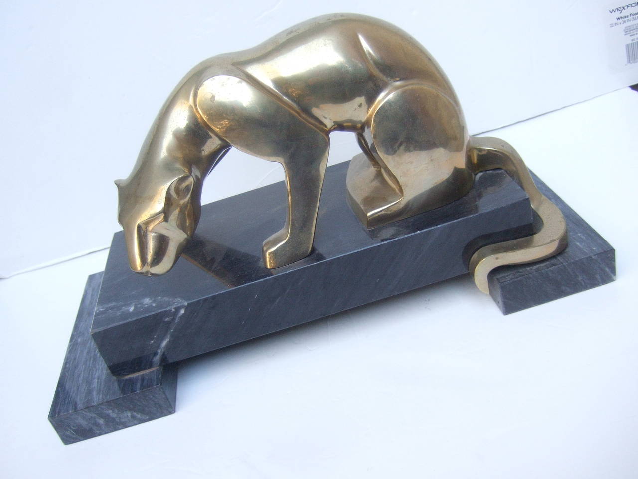 Sleek brass metal panther figure on marble base c 1970s
The exotic panther is designed with solid brass metal percehed on a smokey gray marble base with veining streaks

The stylized panther statue while designed much later has an art deco