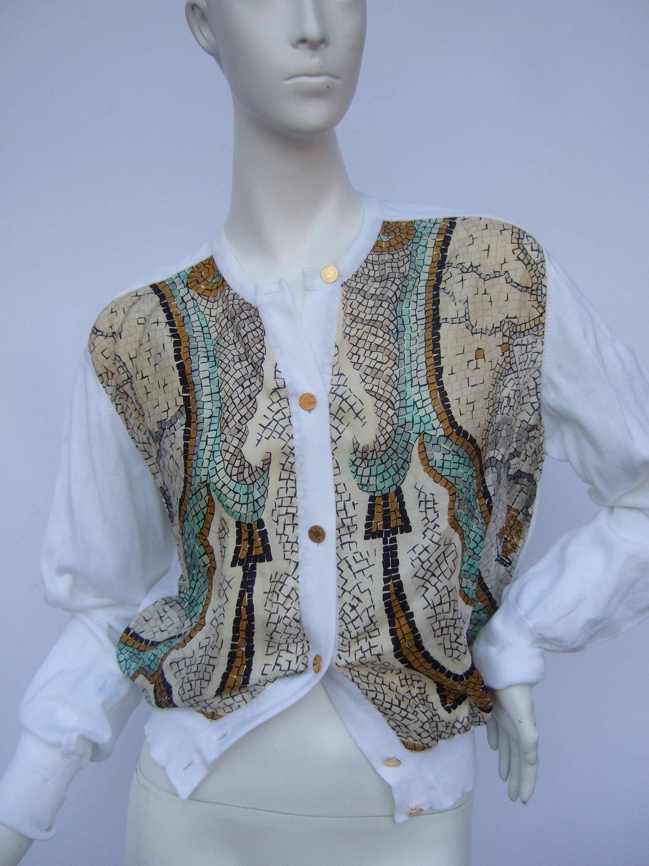 Hermes Paris Silk & cotton gilt button cardigan Size 42
The elegant cardigan is designed with silk print panels on the front
The stylish cardigan is embellished with six gilt metal Hermes buttons running down the front. An extra gilt metal