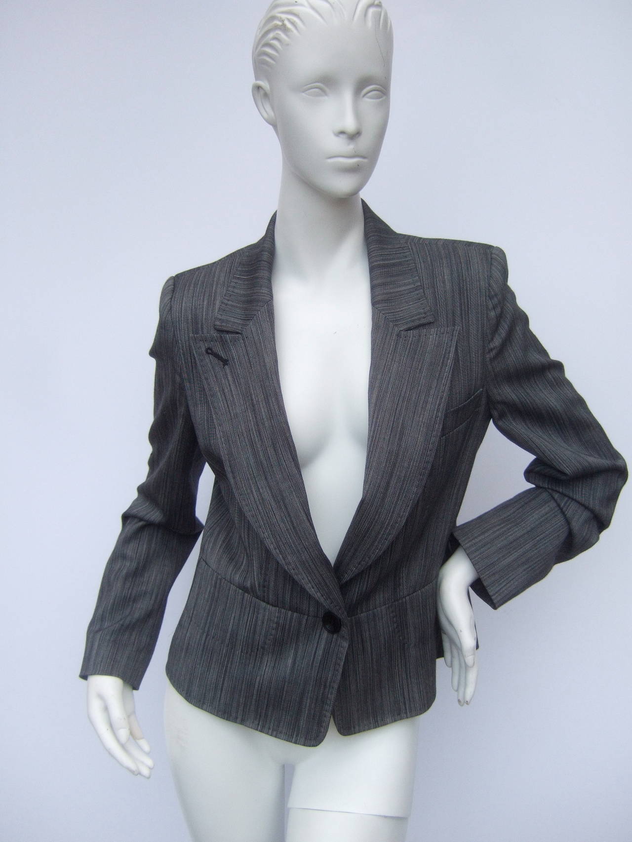 Herve Leger Paris Gray wool tailored jacket US Size 4
The stylish designer jacket is light weight wool with two tone gray colors  The wool is designed with a subtle herringbone striped pattern

The chic jacket is designed with saddle stitch