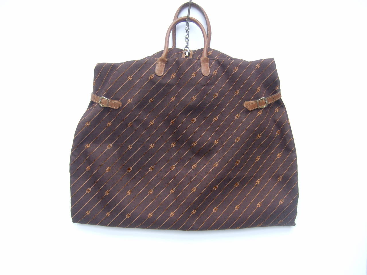 Gucci Brown canvas leather trim garment bag c 1970s
The stylish designer garment bag is designed with brown canvas with Gucci's interlocked initials repeated throughout. The handles & latch buckles are light brown leather

The versatile Italian