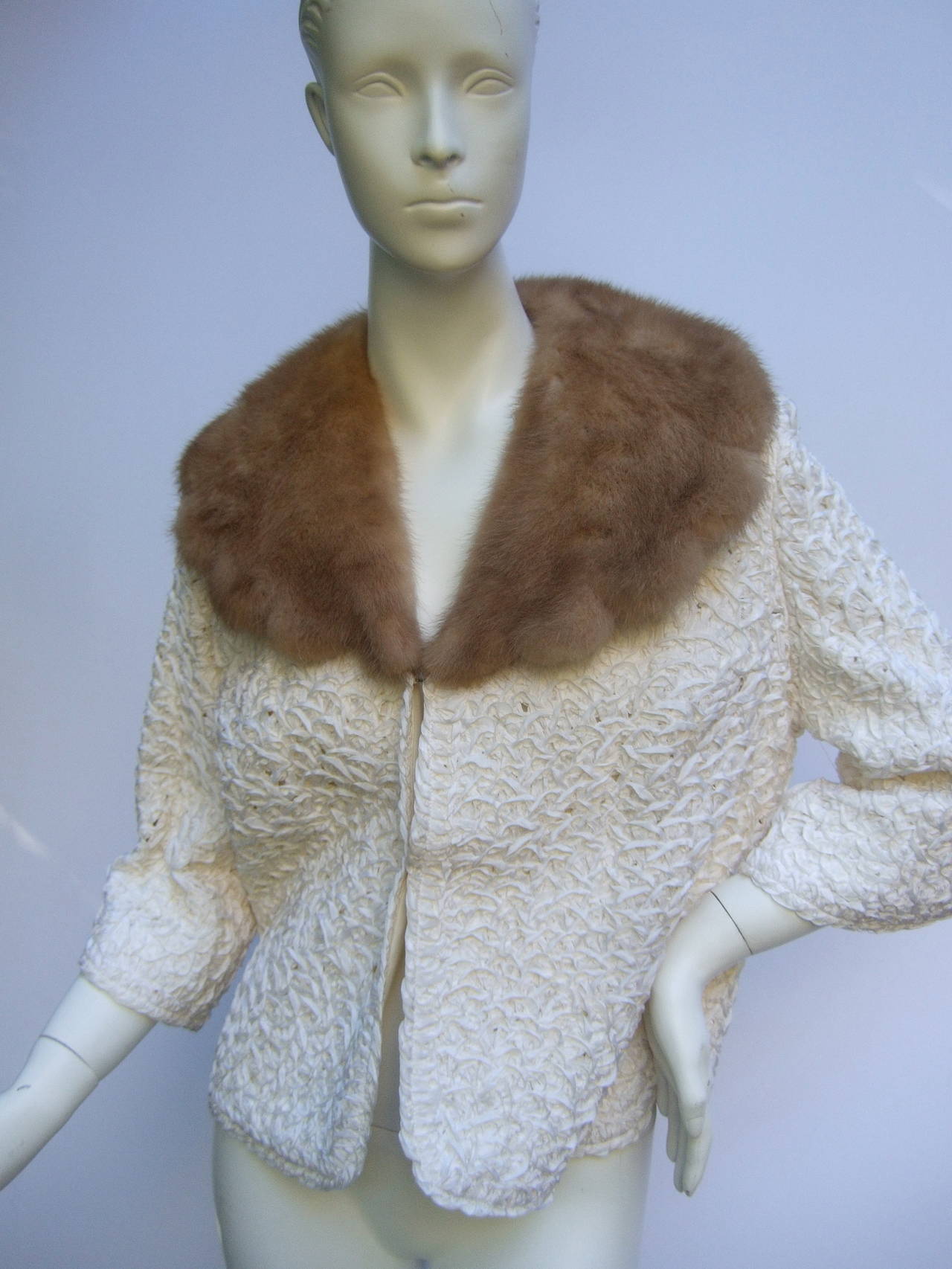 Mink collar white ribbon jacket c 1960
The chic retro ribbon jacket is designed with a wide dramatic scalloped mink collar. The elegant jacket is constructed with intricate looped satin ribbons
The back hemline & cuffs are designed with a subtle