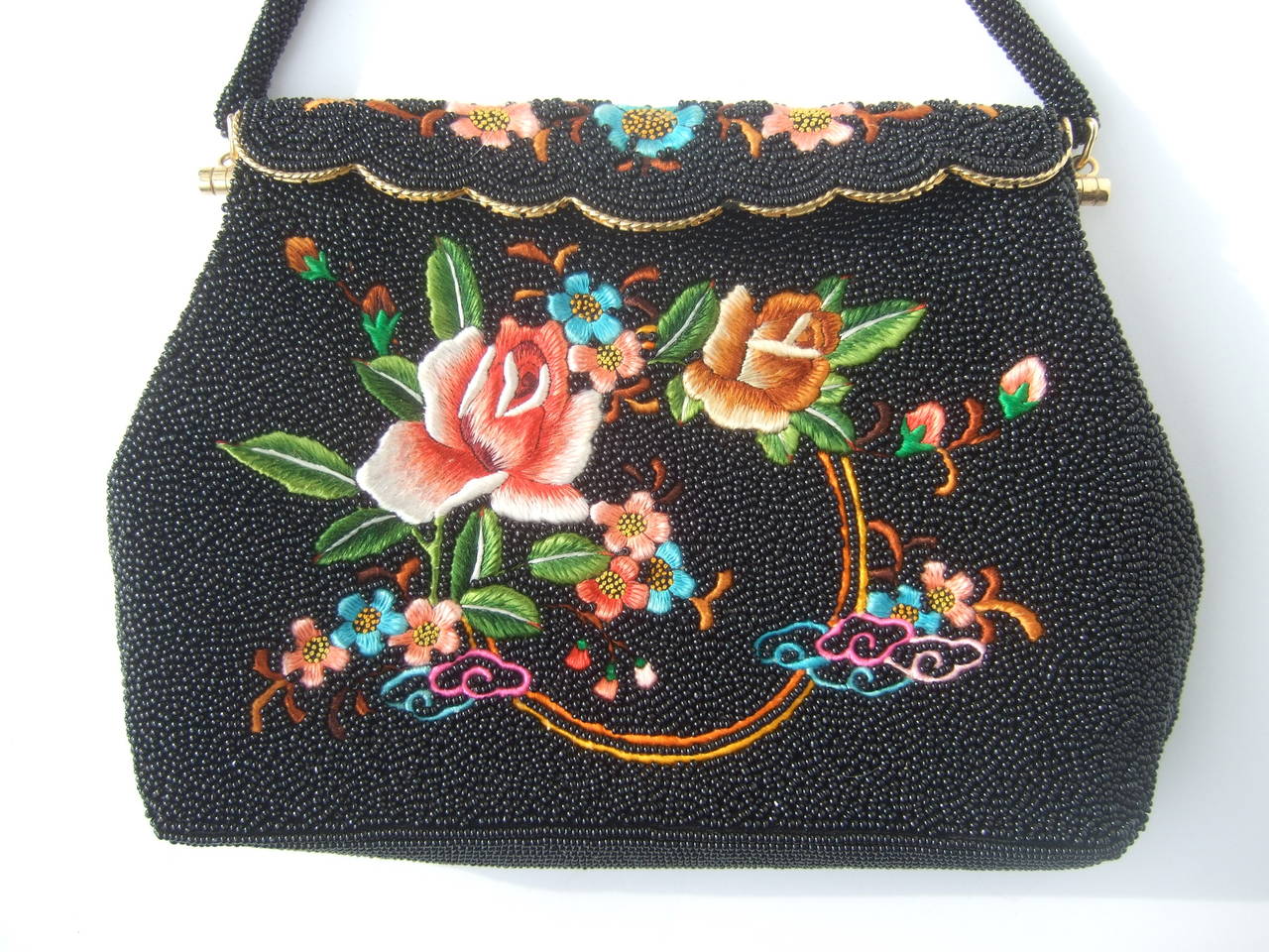 Exquisite schwarze Abendtasche mit Glasperlenstickerei um 1960
Die wunderschöne Abendtasche im Vintage-Stil ist auf allen Seiten mit Mikro-Glasperlen verziert. Die Vorderseite der Handtasche ist mit aufwendigen handgestickten Blumen verziert

Der