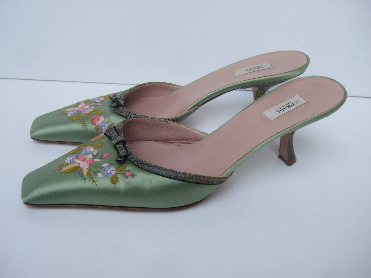 Prada Mint green satin embroidered flower mules. Made in Italy Size 37.5
The stylish designer mules are accented with a bouquet of lavender 
embroidered flowers

The front of the shoes are trimmed with green embossed leather & bows
The heels