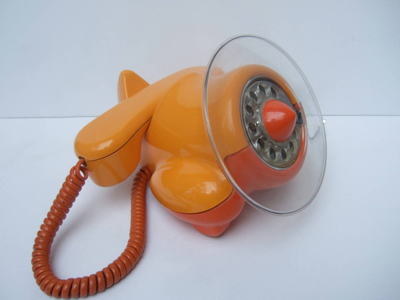 Whimsical mod novelty airplane telephone c 1970s
The unique rare telephone is designed in the shape of an airplane with a clear lucite propeller rotary dial. The avant-garde telephone is designed with sleek tangerine & mellen color contrasting