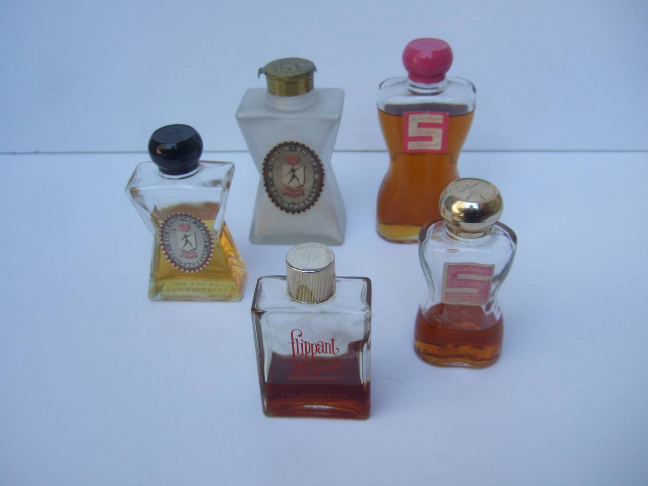 Collection of vintage Schiaparelli perfume bottles c 1950s
The assortment of vintage perfume bottles varies in fragrance & bottle size
The largest Schiaparelli Shocking bottle is a 4 oz crystal torso bottle that is paired with a fuchsia pink satin